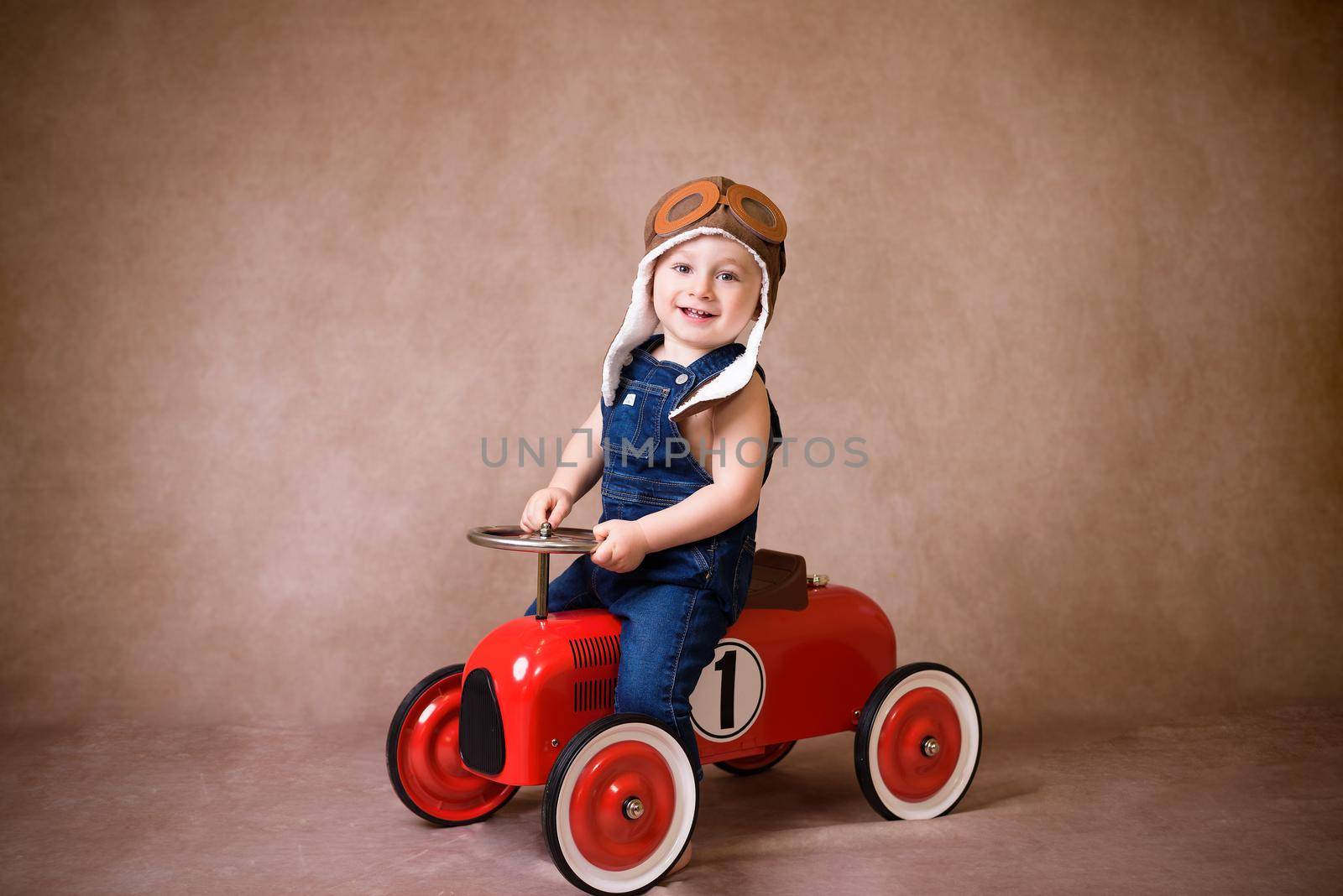 Little boy, playing with wooden cars, indoor, suitcases behind him by jcdiazhidalgo