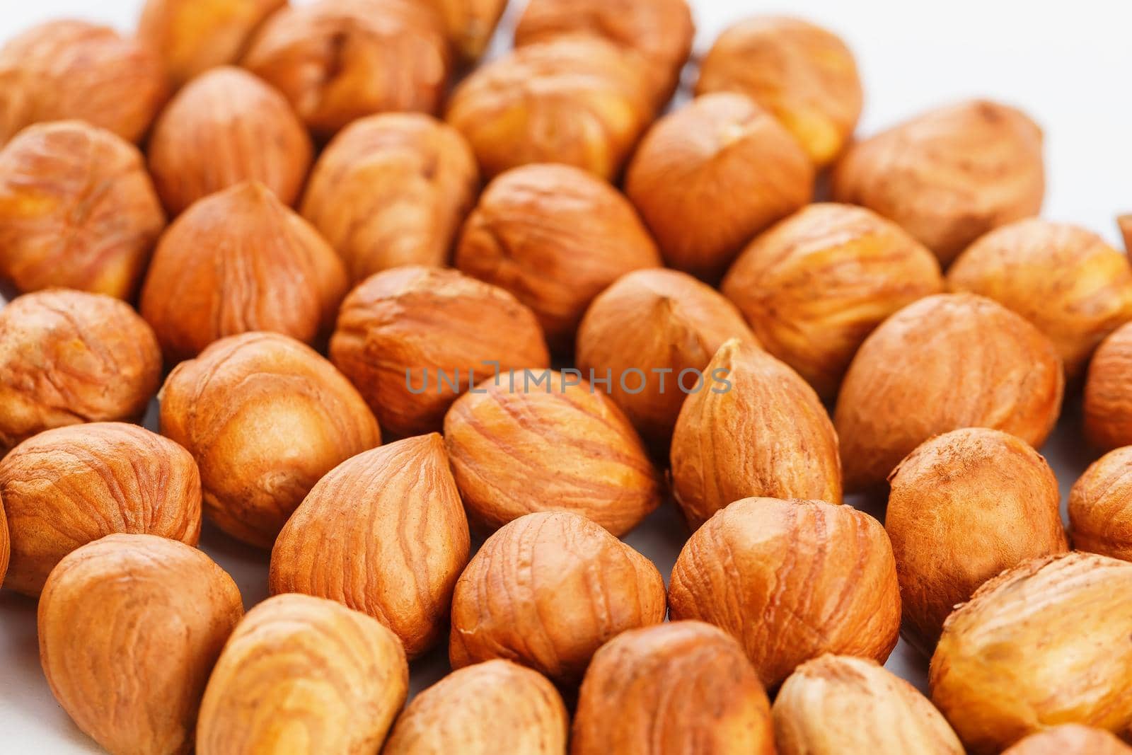 Heap of hazelnuts isolated on white background, macro image.