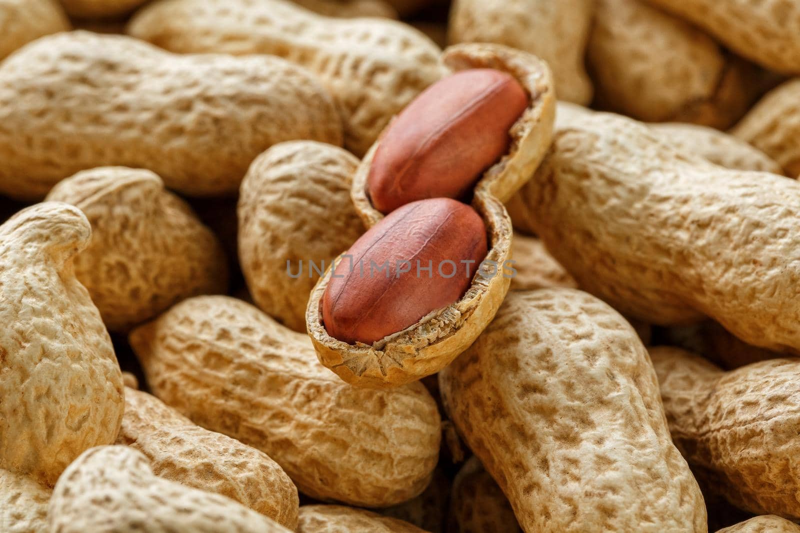 Peeled peanut on well peanuts. Uncleaned inshell peanuts. Peanuts, for background or textures.