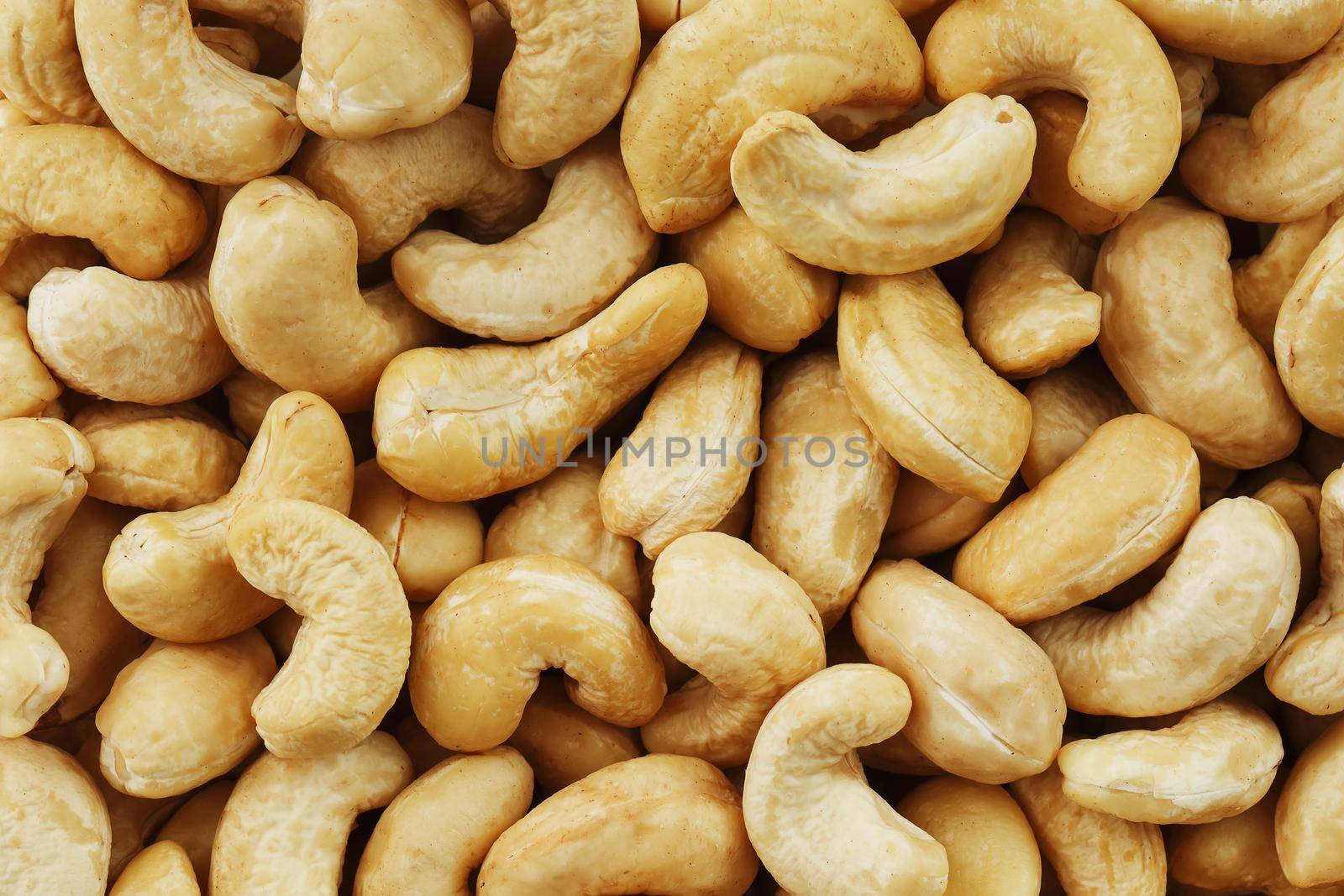 Organic cashew without shell on the background. Organic golden walnut closeup. Macro shot plan.