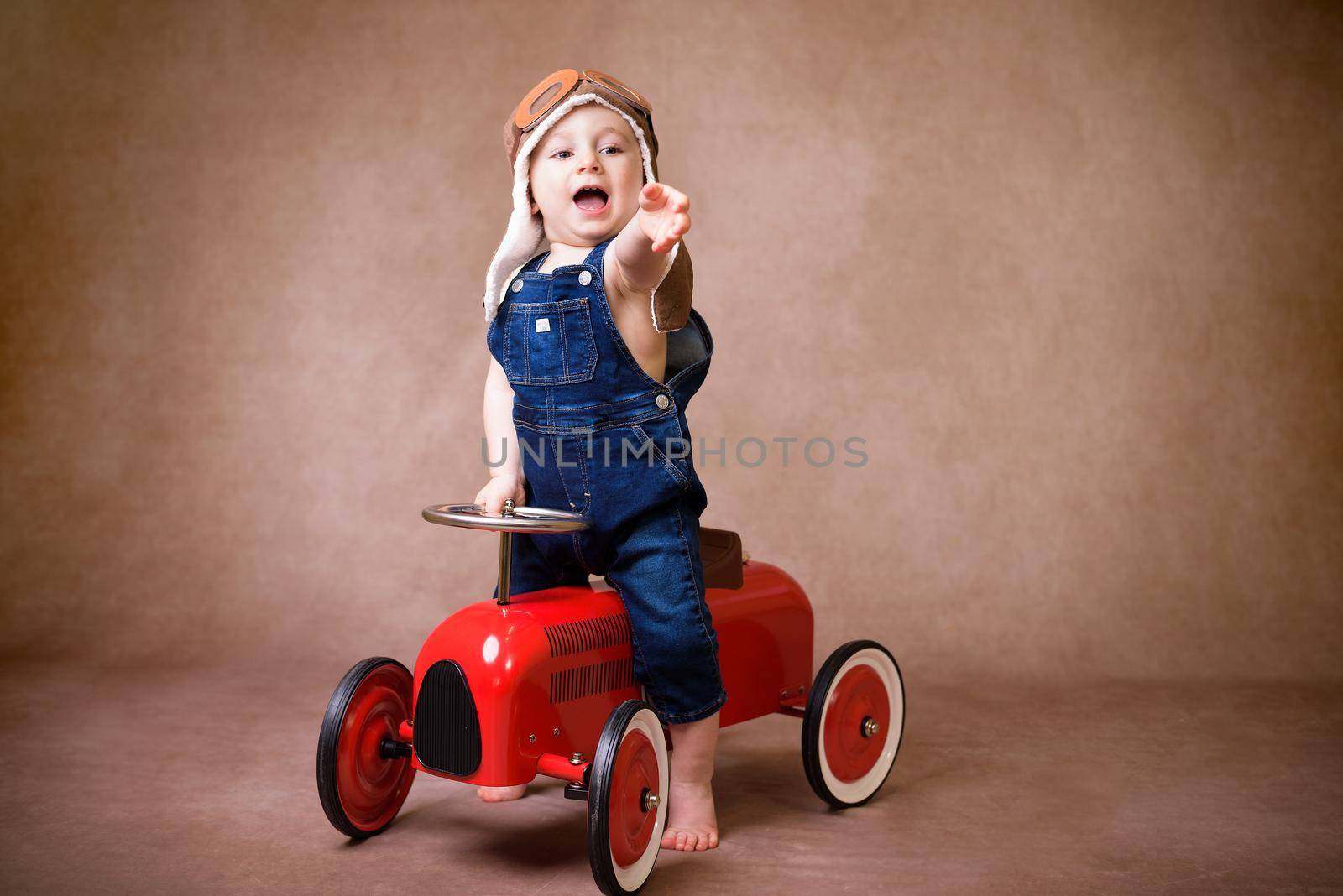 Little boy, playing with wooden cars, indoor, suitcases behind him by jcdiazhidalgo