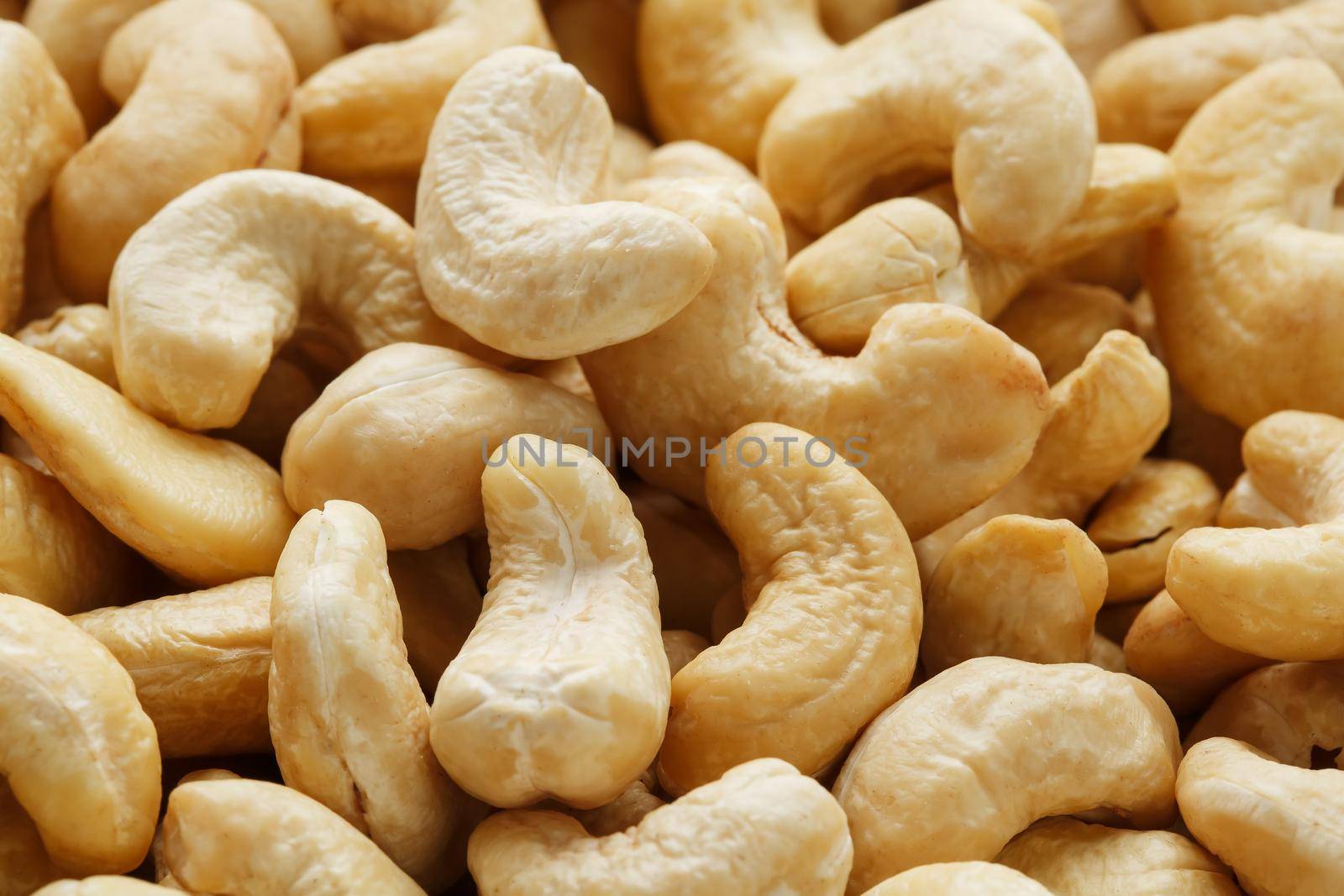 Organic cashew without shell on the background. Organic golden walnut closeup. Macro shot plan.