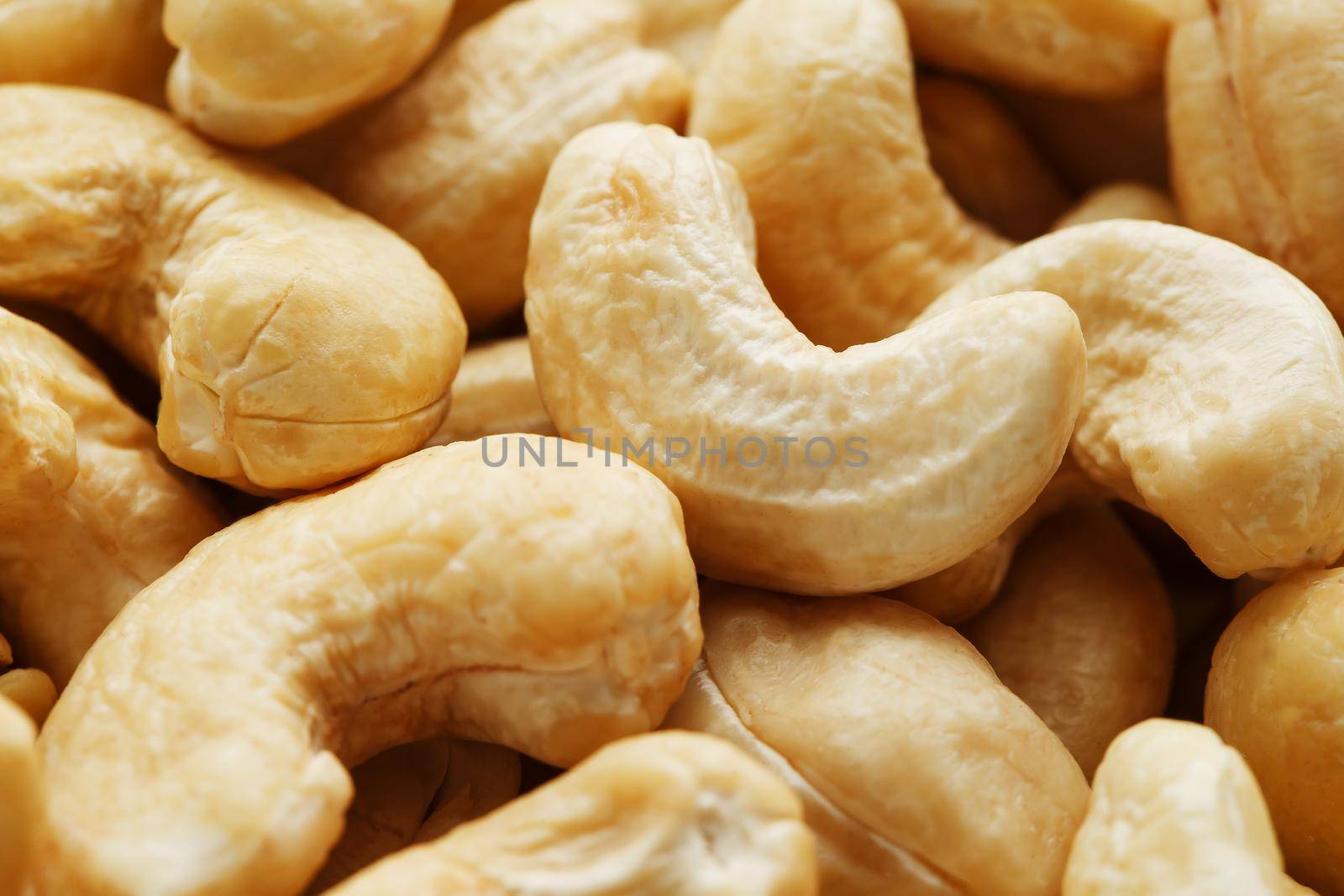 Organic cashew without shell on the background. Organic golden walnut closeup. Macro shot plan.