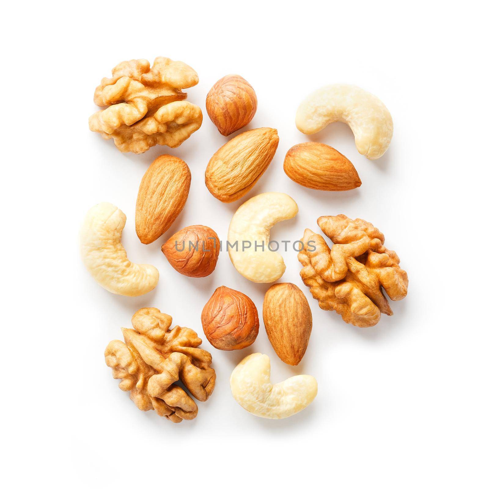 Isolated nuts pattern background. Walnut, cashew, almond and hazelnut on white background. View from above. by AlexGrec