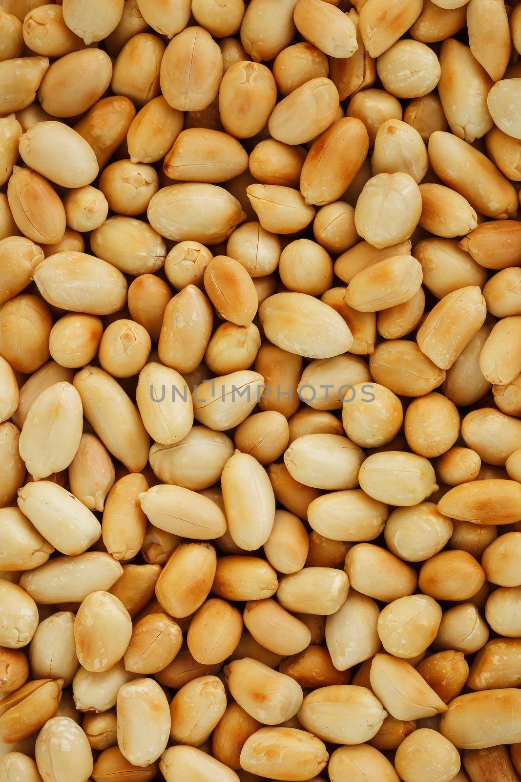 Peanut texture. Food background of peanuts bean. Golden, roasted organic peanuts. Wholesome organic legumes. Close-up, macro.