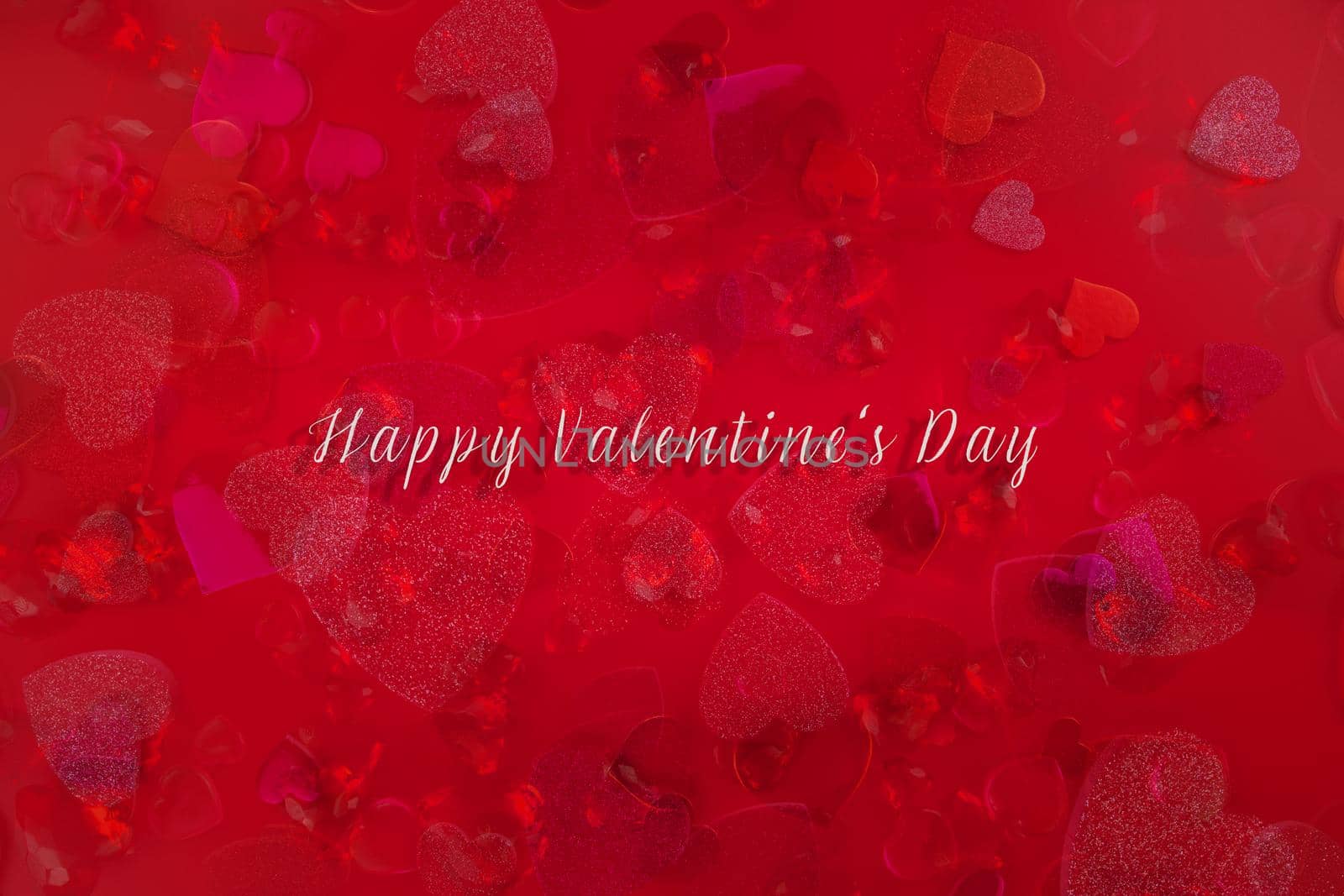 Valentine's Day Heart Abstract Multiple Exposure Background. Predominantly red image with hearts of different sizes, colors, and textures, including shiny, glittery, and gemstone. Lots of copy space. Includes the words, Happy Valentine's Day