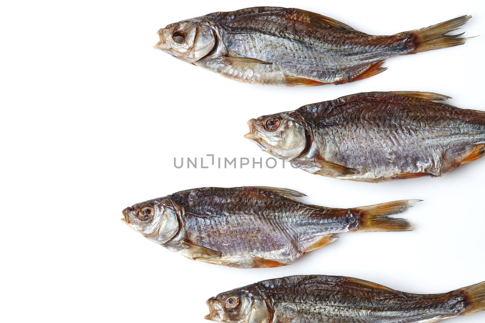 Dried or jerky salted taranka, yummy clipfish isolated on white background. Popular beer appetizer. Traditional way of preserving fish. Close up, copy space, top view