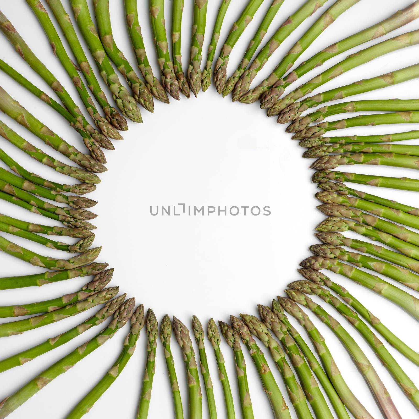 Ripe raw asparagus stems laid out in circle, isolated on white background. Concept of healthy nutrition, food and seasonal vegetables harvest. Close up, copy space. Flat lay, top view