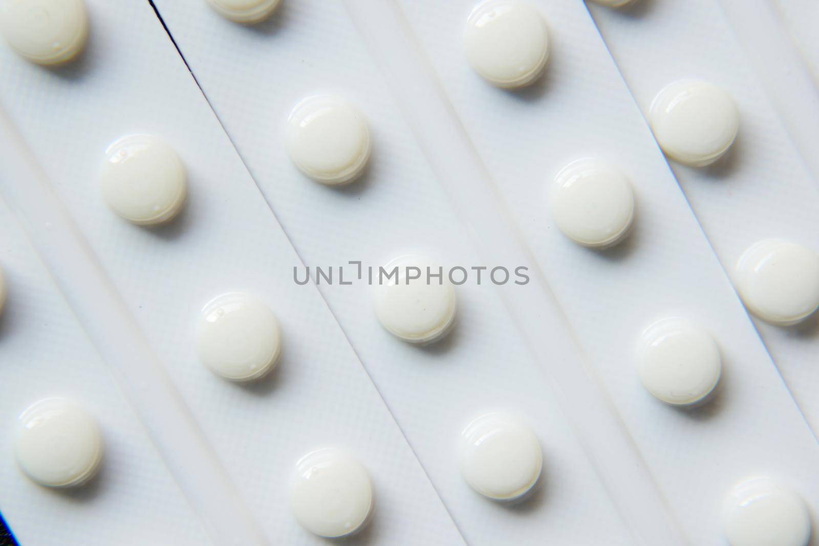 Close up of pills of blister pack on table .