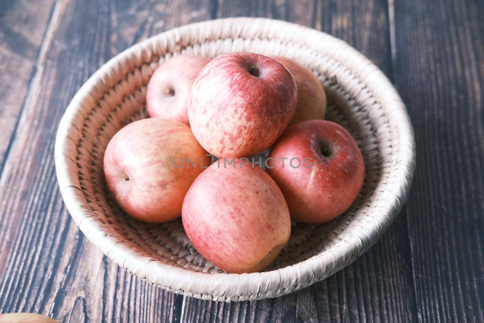 Close up of fresh apple in a bowl on wooden table.