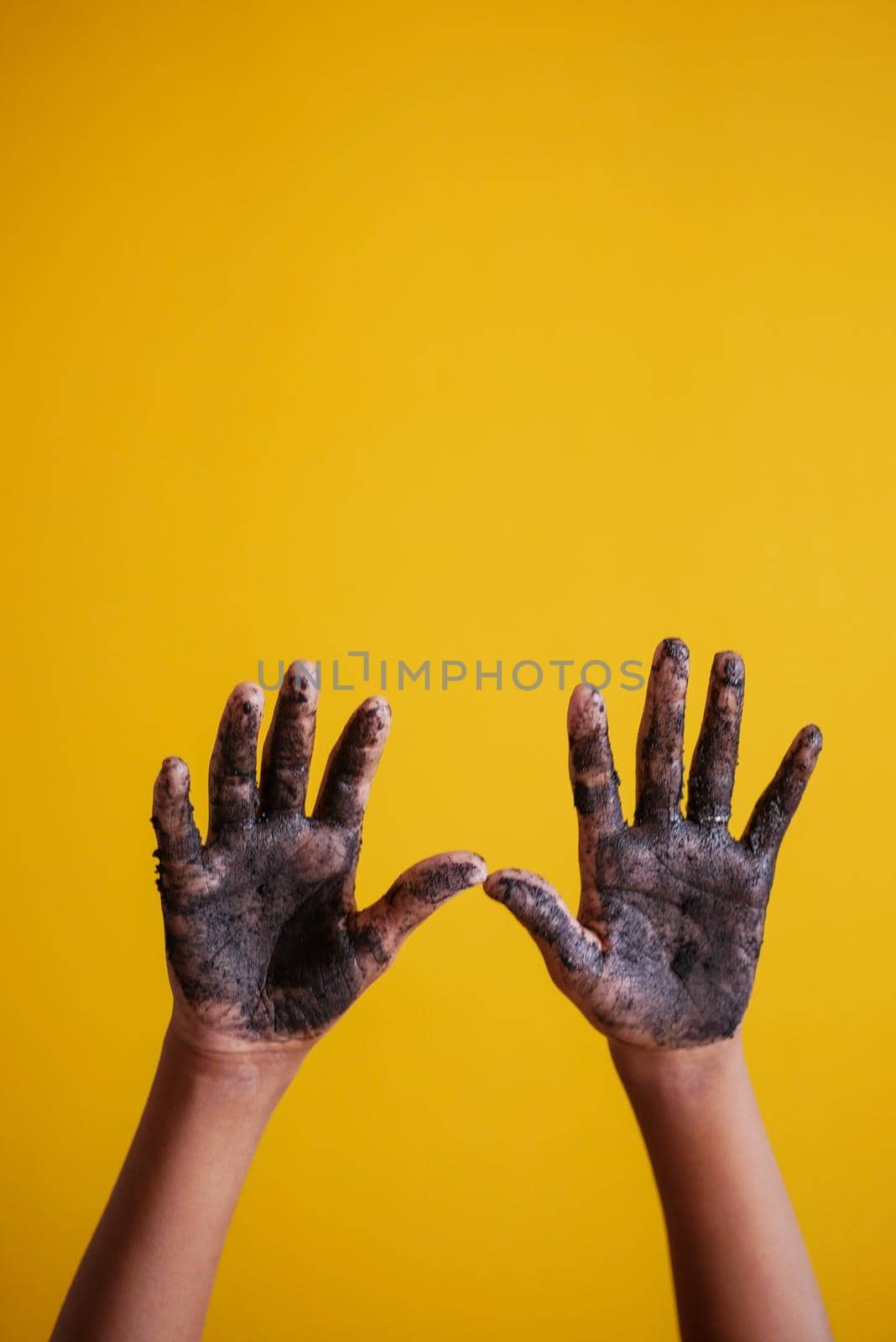 hand dirty with soil against yellow background by towfiq007