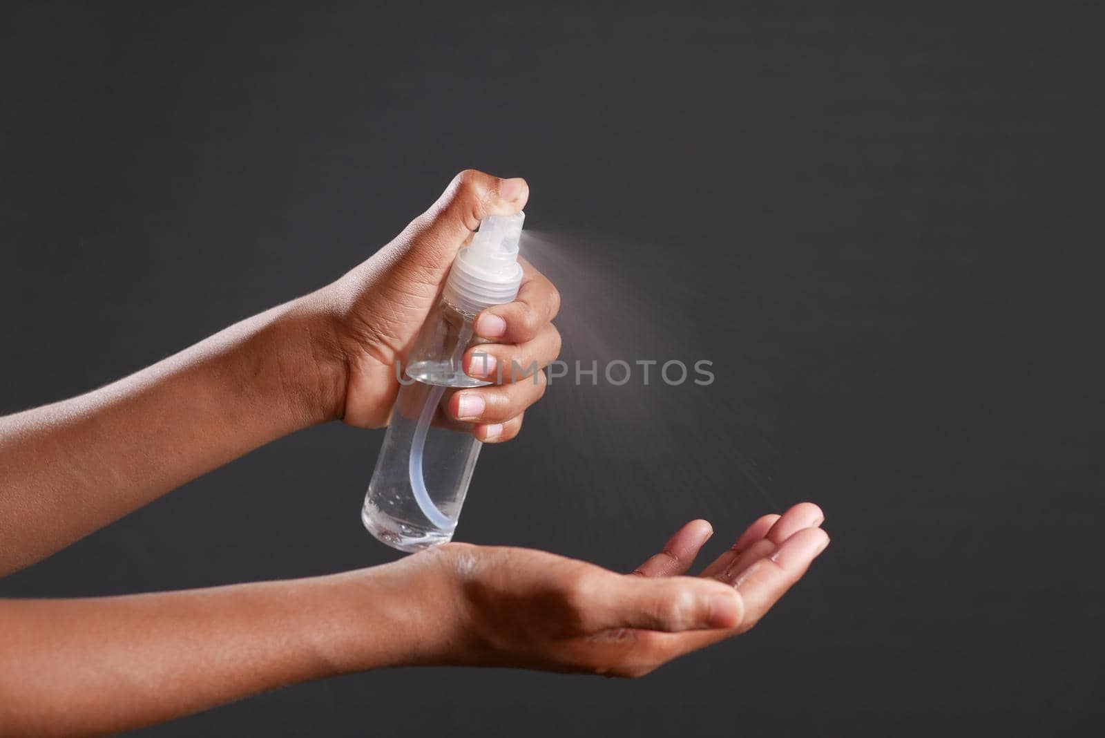 close up of young man hand using hand sanitizer spray