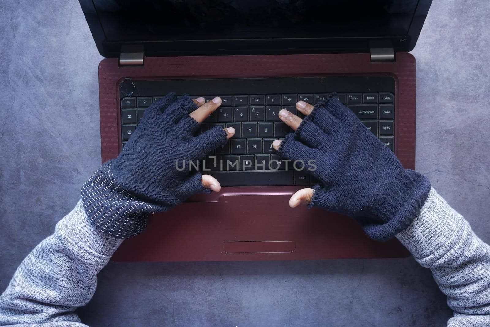 hacker hand stealing data from laptop top down.