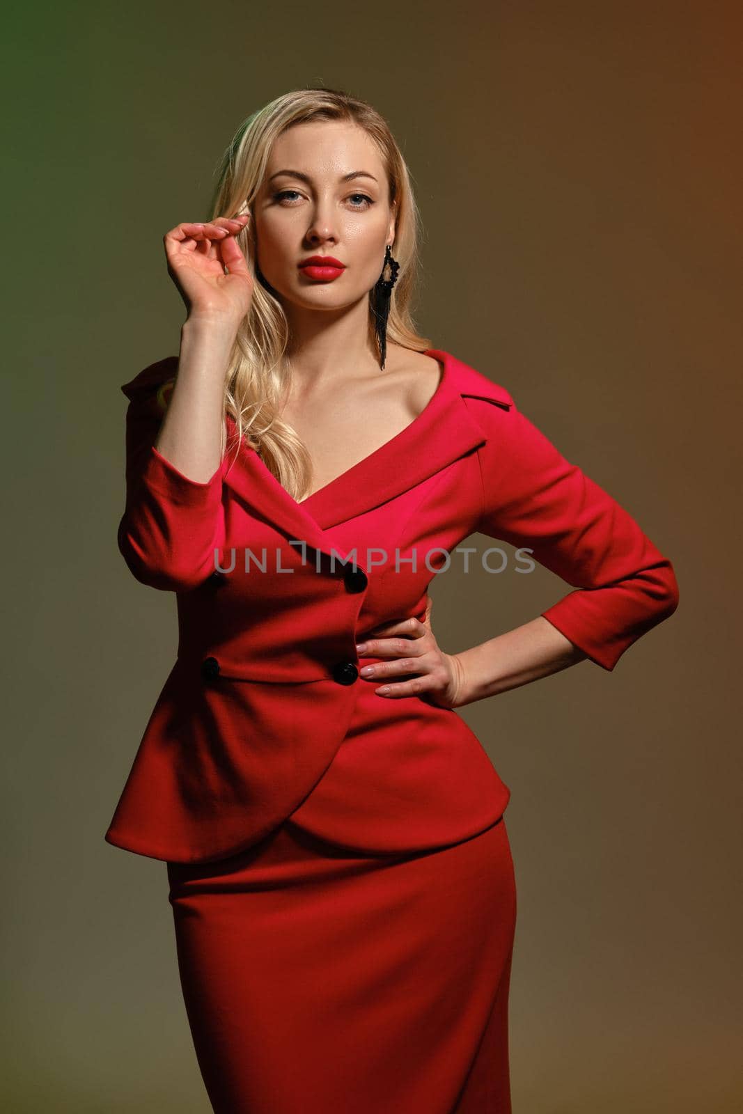 Blonde lady in red dress and black earrings. Holding something, posing on colorful background. Template, mockup for your advertising. Close up by nazarovsergey