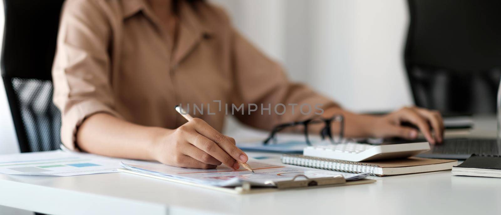 Close up business woman using calculator and working to calculate about finance accounting at coffeeshop outdor. finance accounting concept.