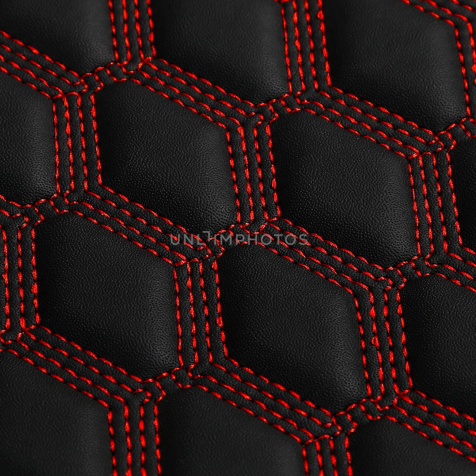 Texture of black leather background with square pattern and red stitch, macro