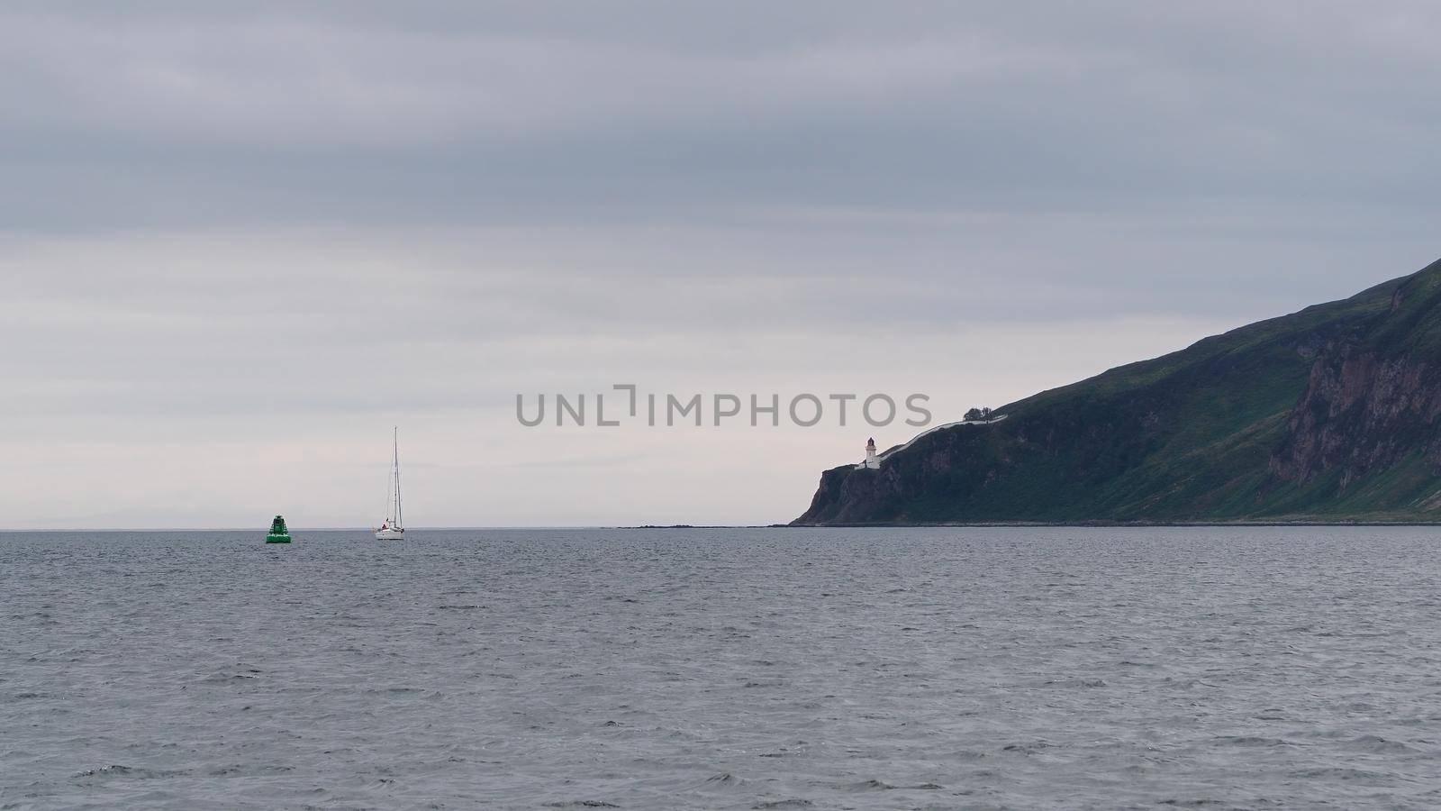 A yacht passes McArthurs Head lighthouse in the Sound of Islay, Hebrides by PhilHarland