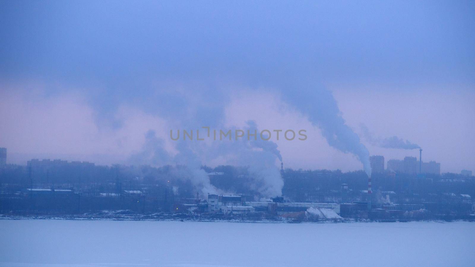 Chimneys smoke in winter against the background of the city and the sky. by Andre1ns