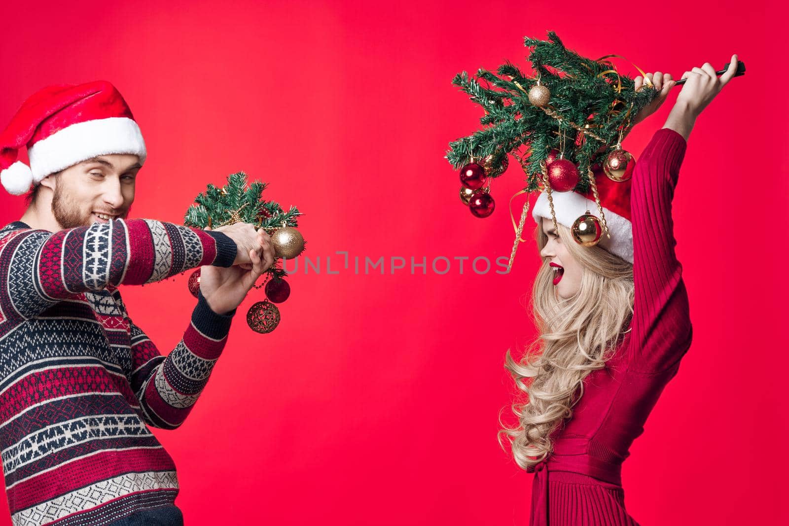 a man and a woman are standing next to Christmas decorations fun holiday by SHOTPRIME