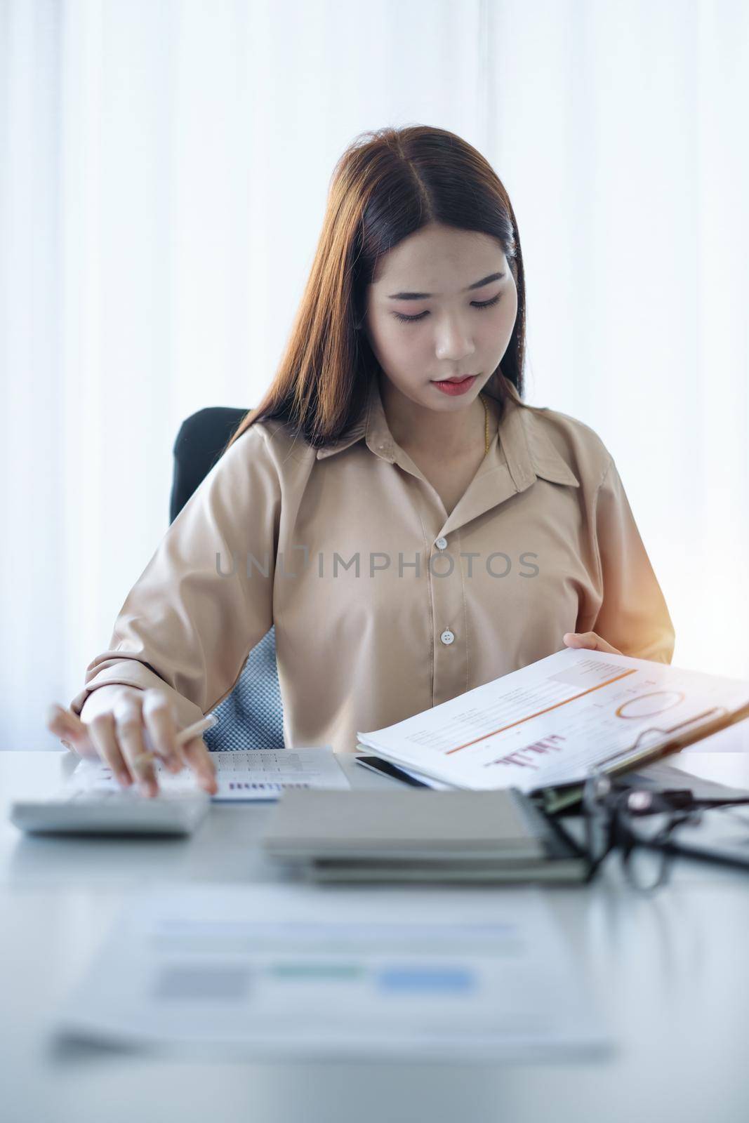 Business woman analyst financial advisor preparing statistical report searching documents on work desk, browsing information by itchaznong