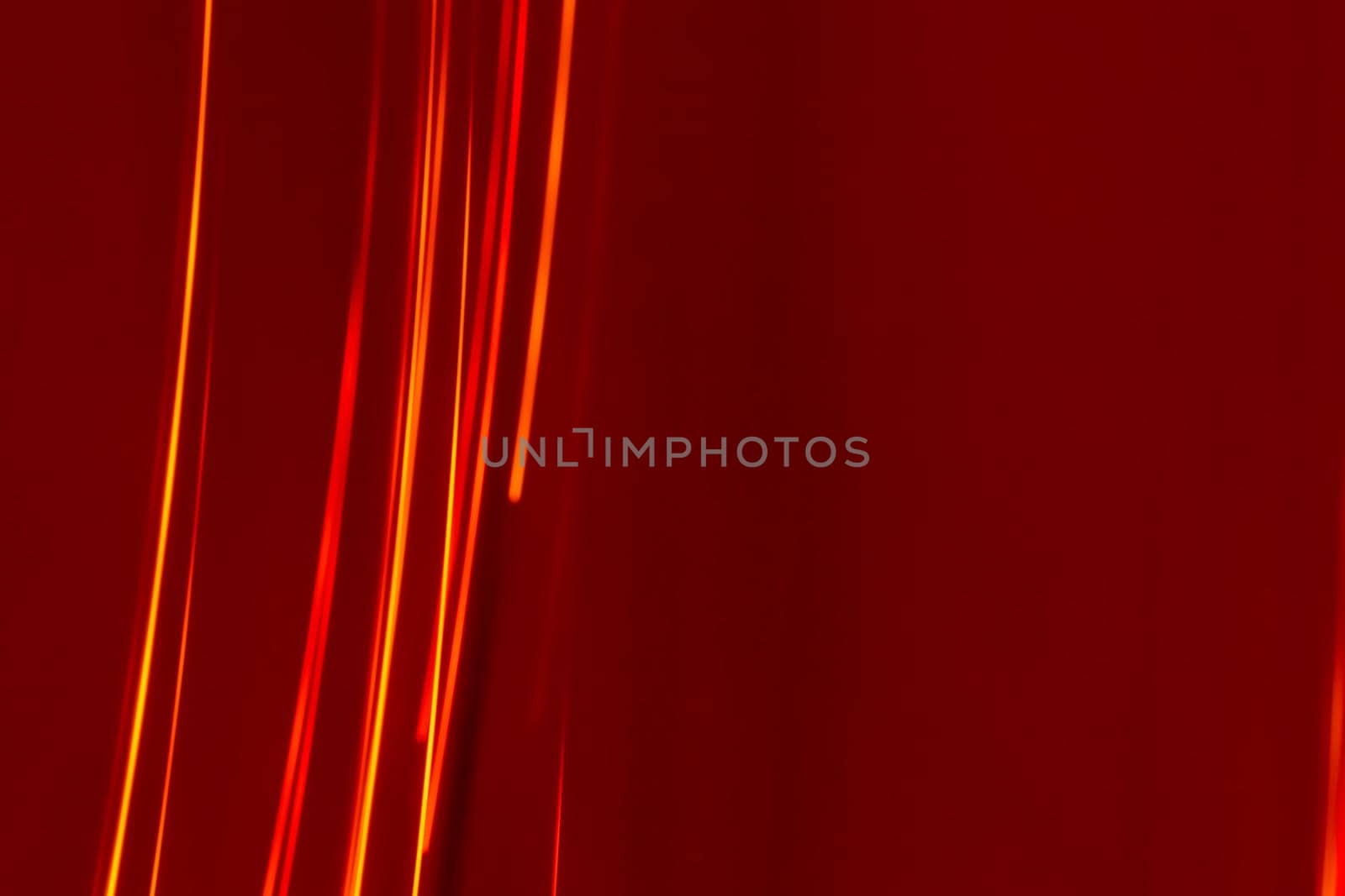 Bright red lines rays on a burgundy background. Abstract backdrop with soft blur. Energy and speed.