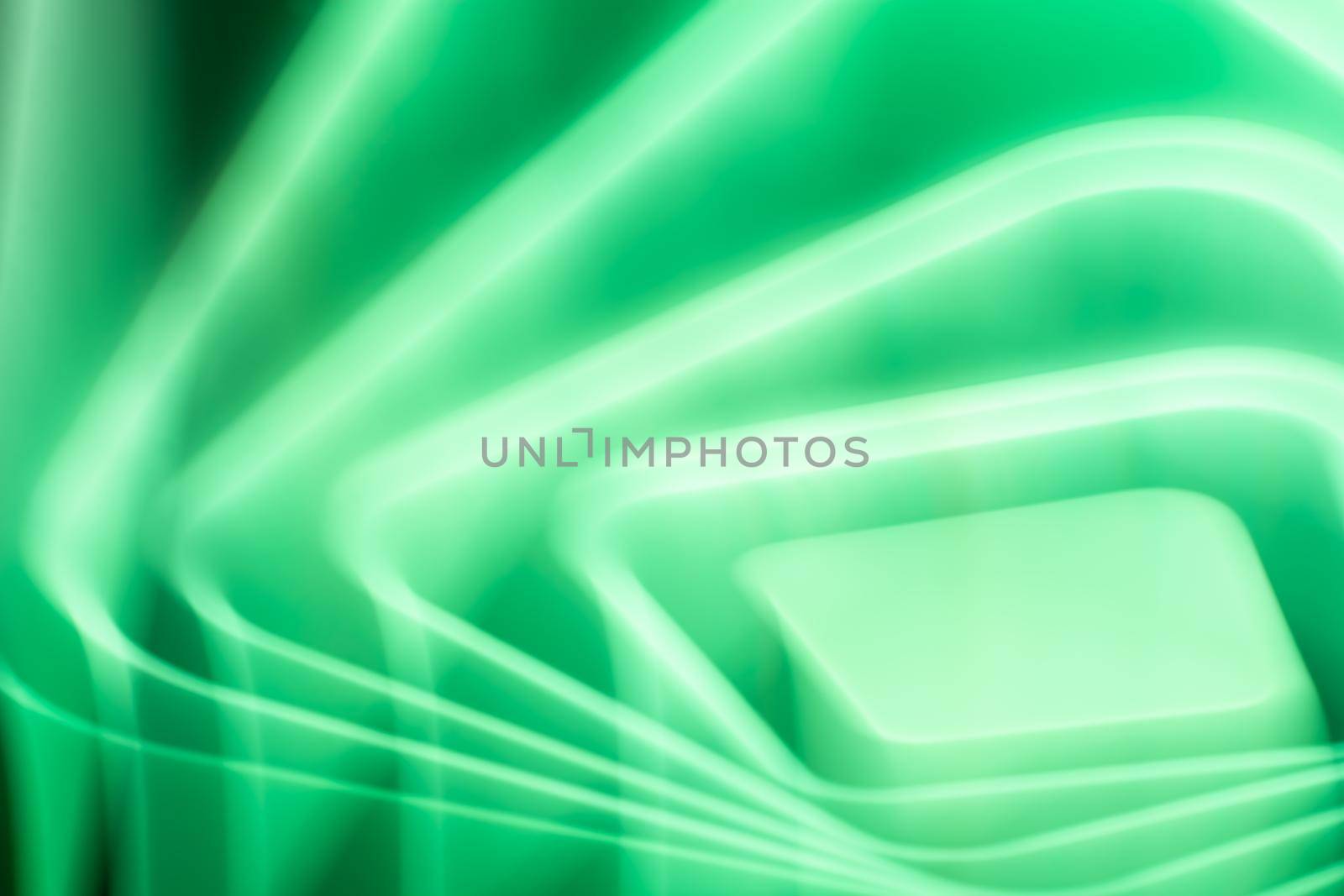 Abstract green glow of a bright LED lamp on the ceiling in the room in the form of waves, squares and rhombuses.