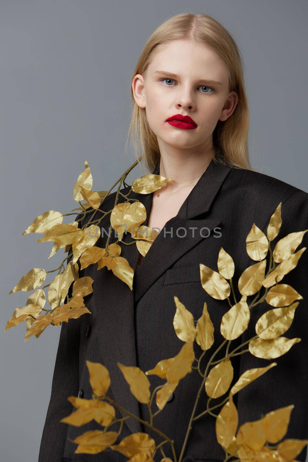 fashionable woman fashion golden leaves in black jacket studio model unaltered. High quality photo
