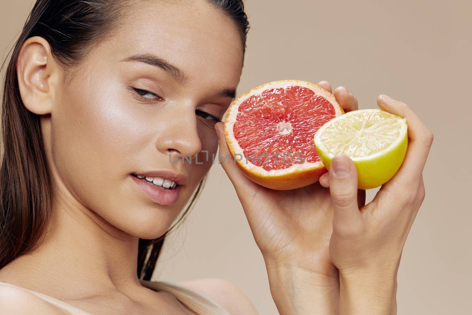 beautiful woman grapefruit with lemon in hands smile vitamins beige background. High quality photo