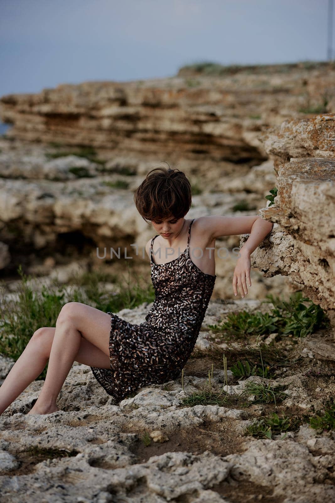 beautiful woman sitting on the stones landscape nature outdoors. High quality photo