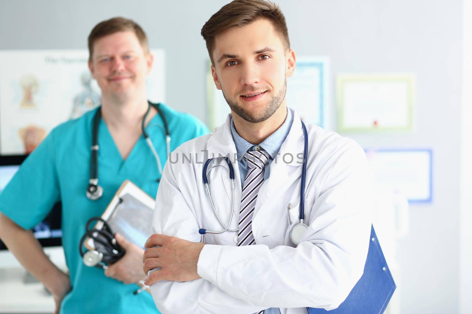 Medical male workers in uniform with stethoscopes, medical help, emergency team by kuprevich