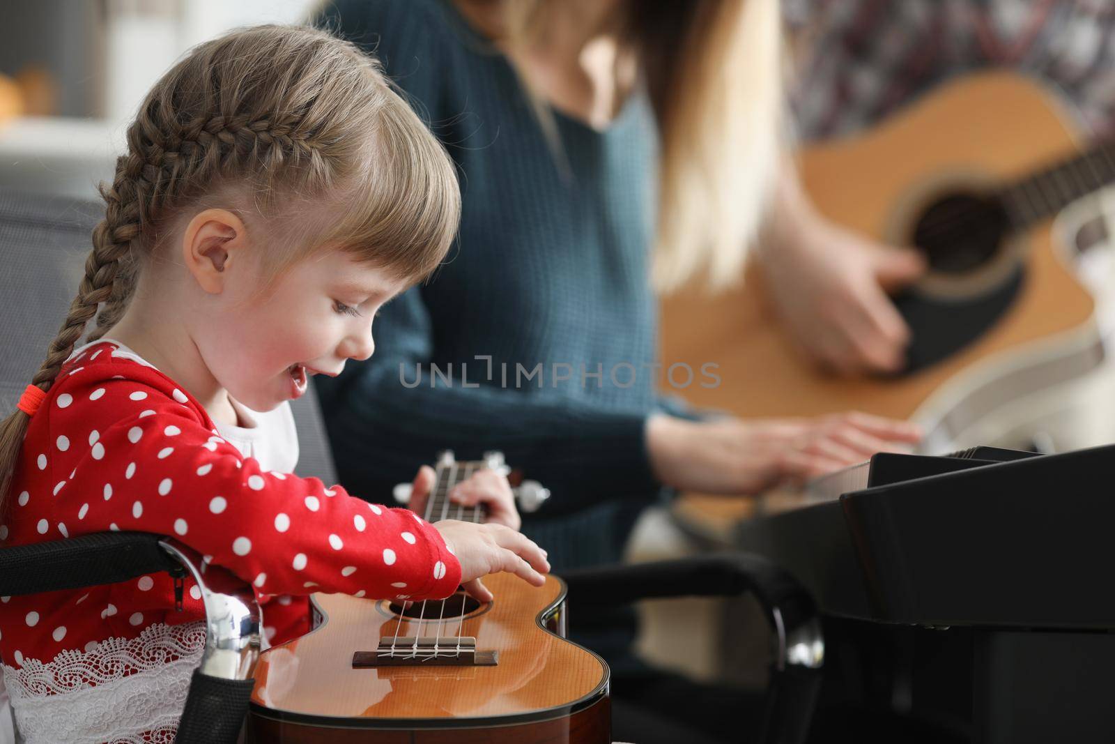 Happy child playing guitar, learn new song on musical instrument by kuprevich