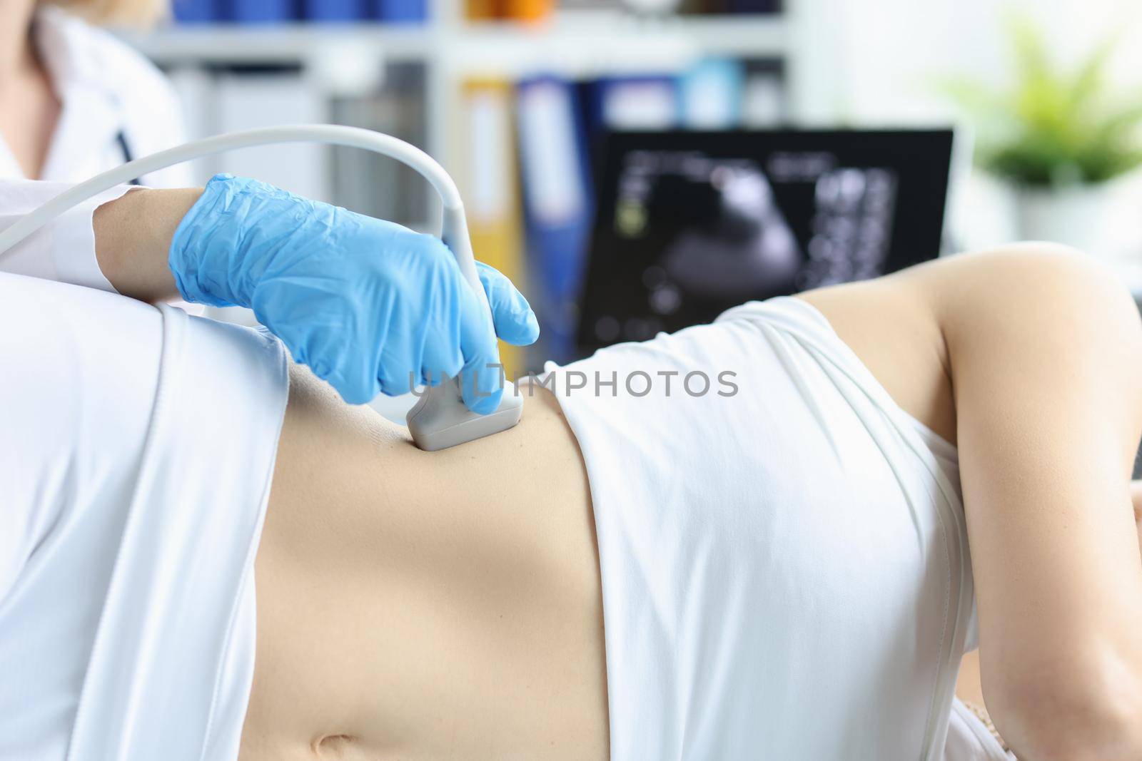 Doctor making ultrasound of kidneys to patient in clinic closeup by kuprevich
