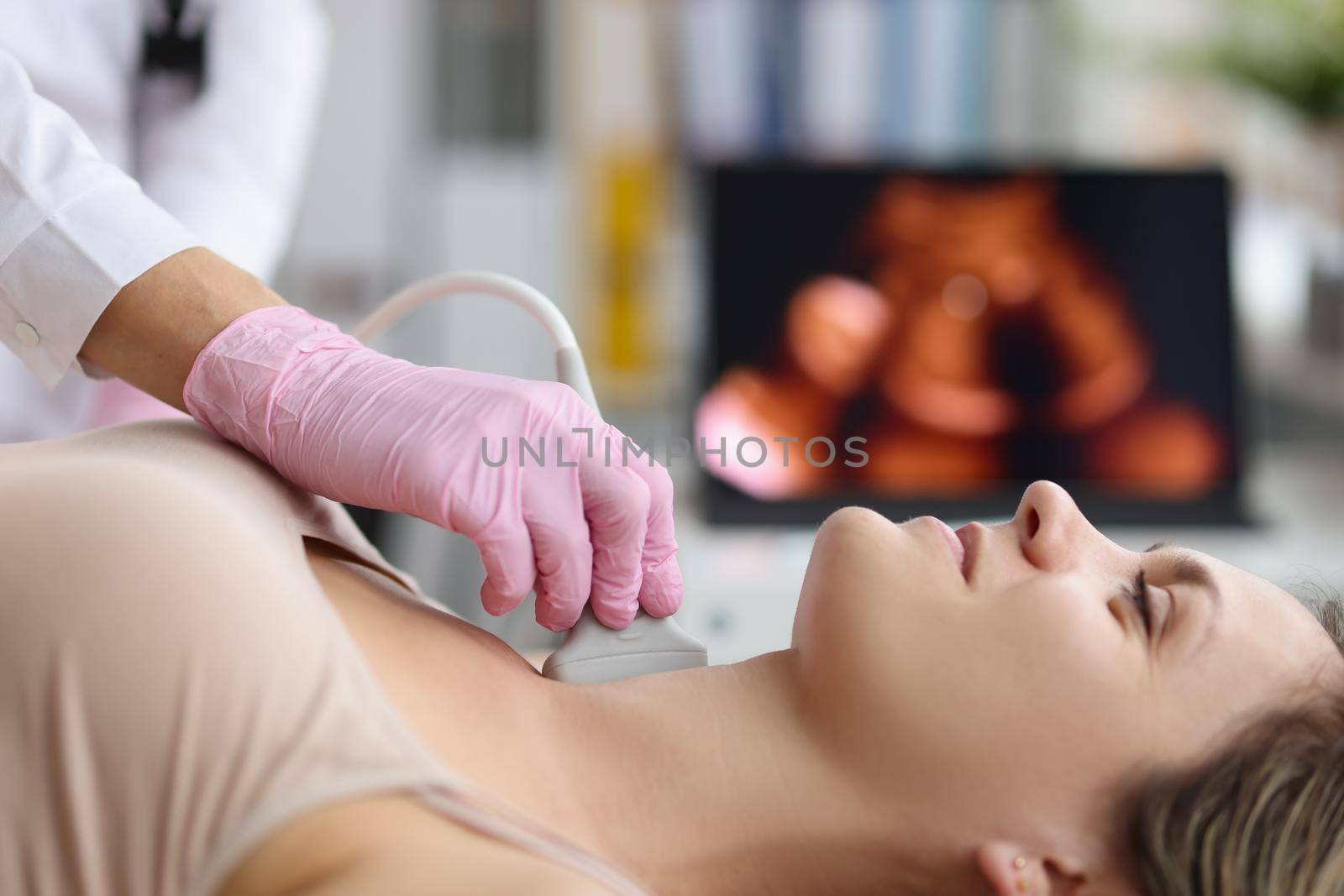 Doctor making ultrasound of thyroid gland to woman patient in clinic. Diagnosis and treatment of autoimmune thyroiditis concept