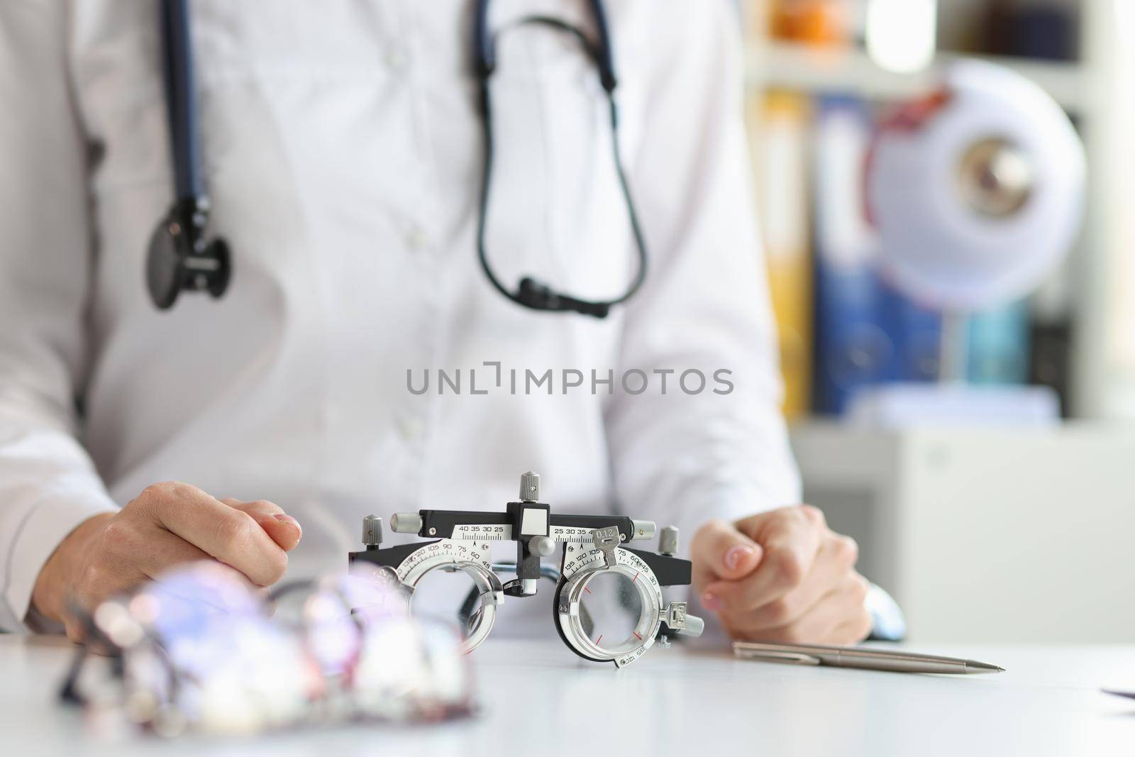 Glasses for checking vision lying on table near doctor ophthalmologist closeup by kuprevich