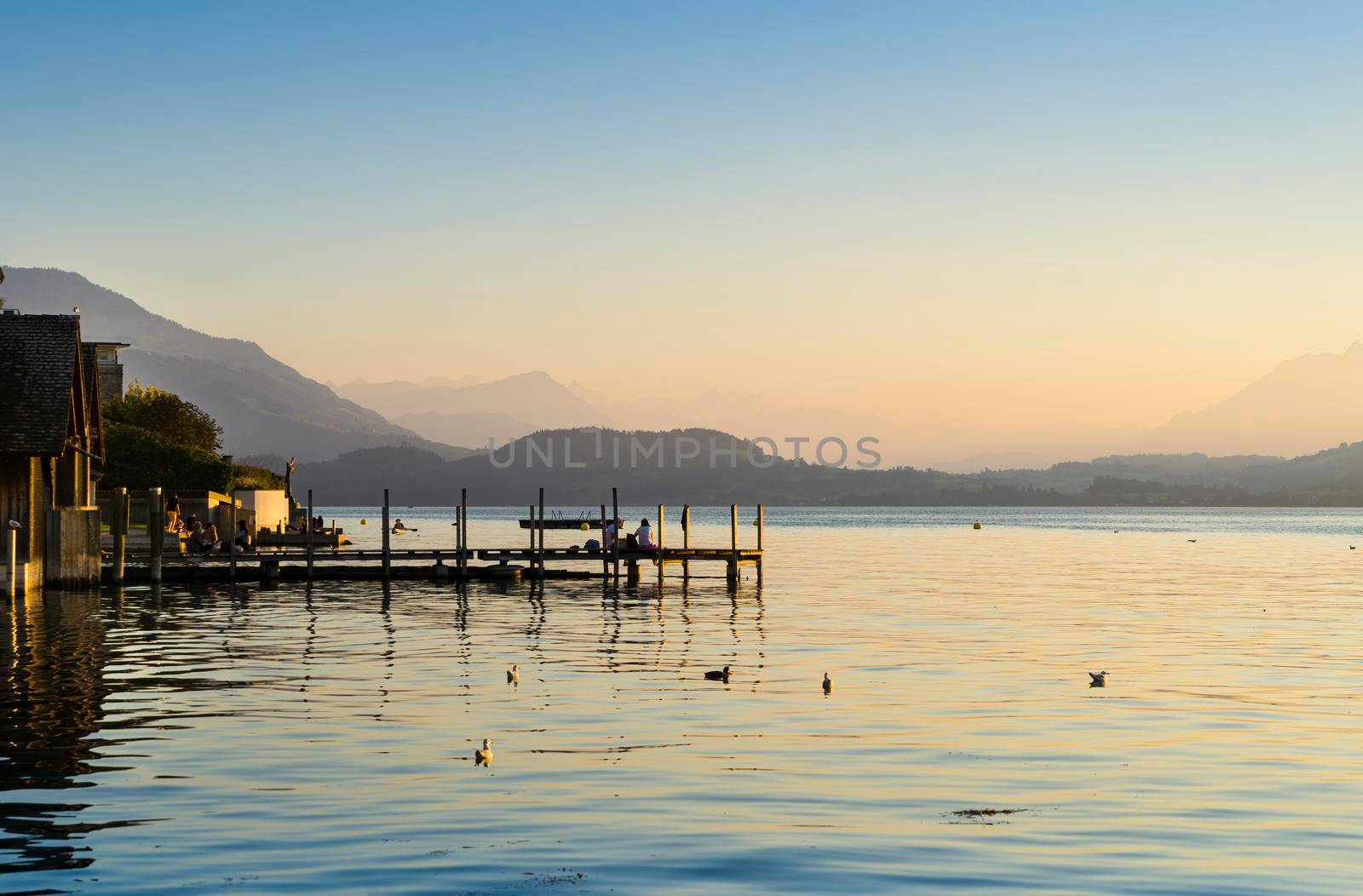 Panoramic landscape of a beautiful pastel sunset over the lake Zugersee in the Swiss town of Zug.