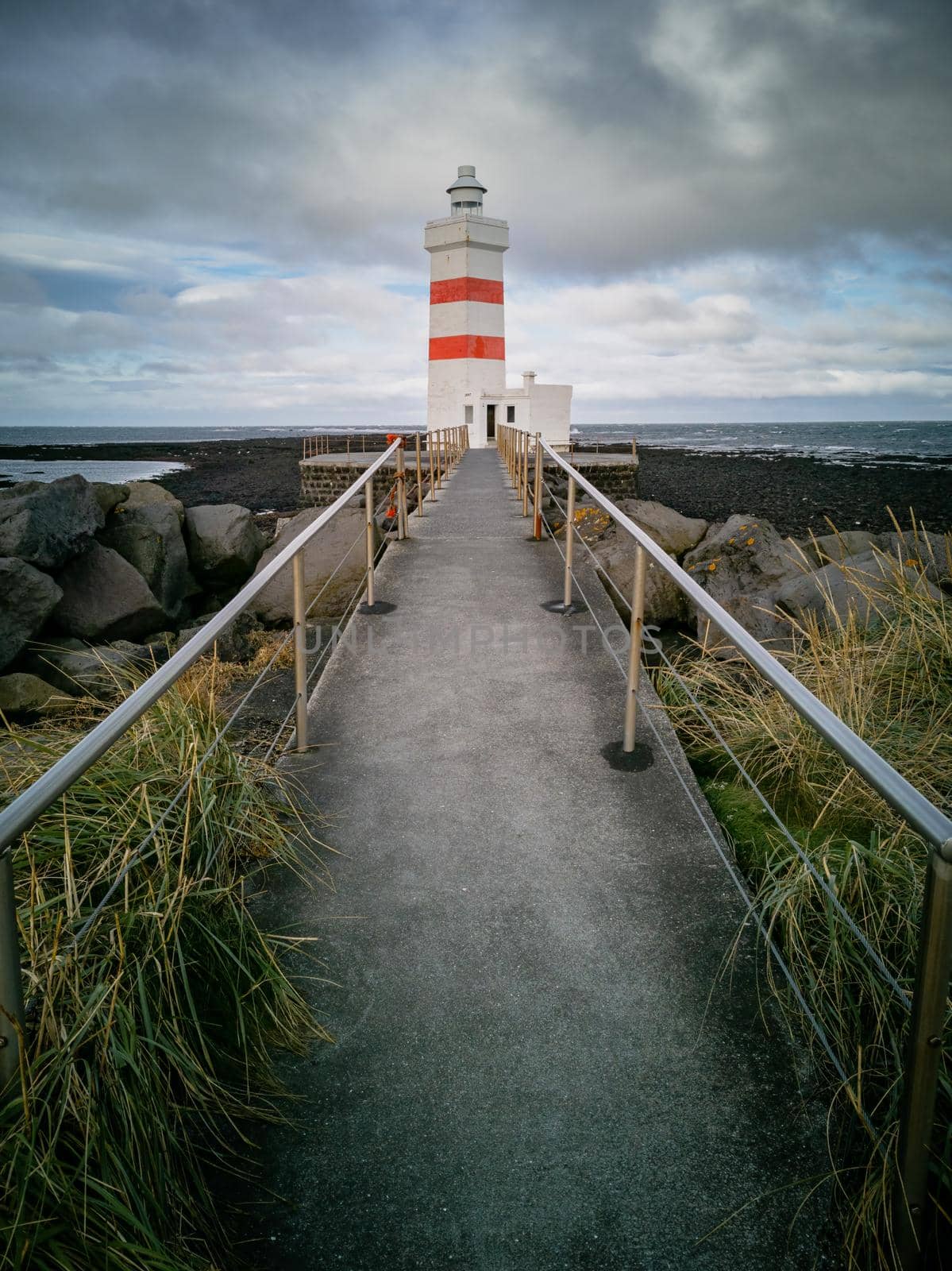 Lighthouse and path under cloudy day and low tide by FerradalFCG