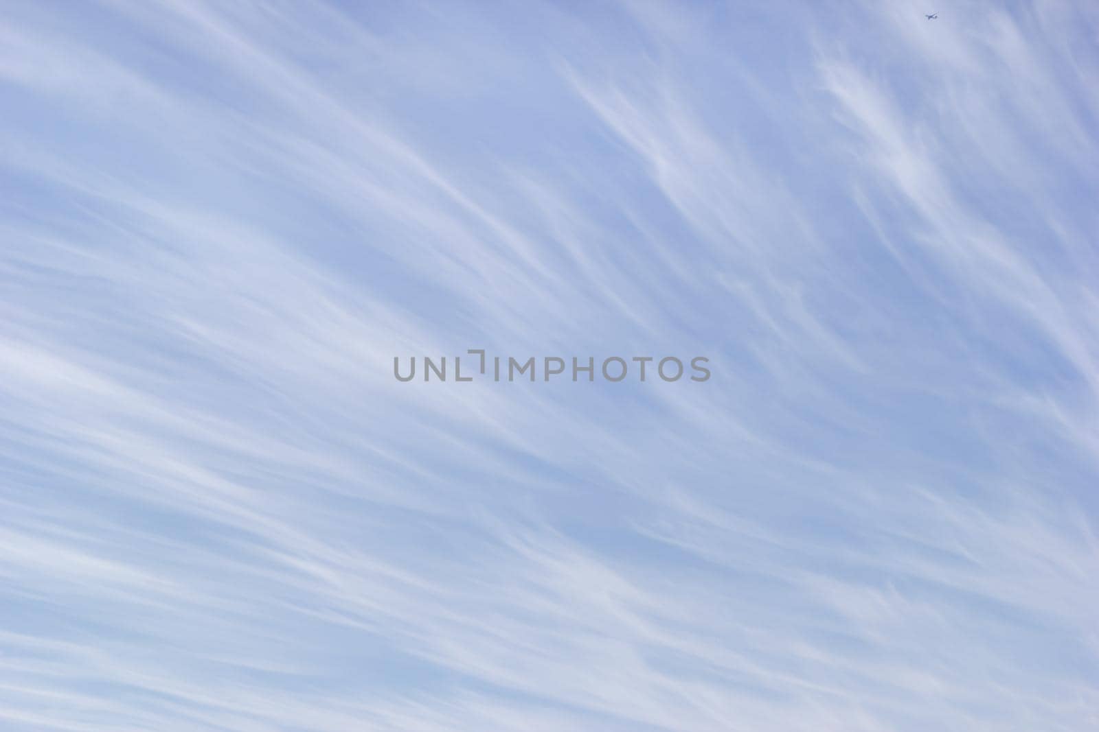 White cirrus clouds on the background gentle blue sky.