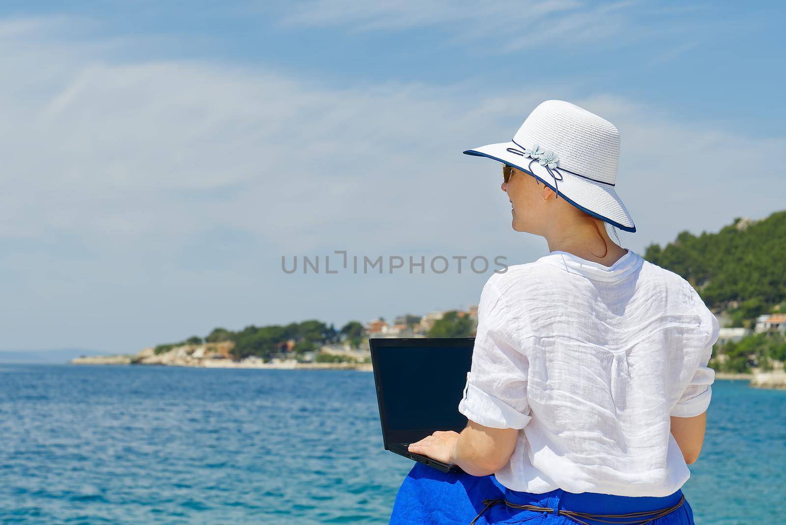 Lifestyle freelance woman using laptop working and relax on the beach. Business and Summer Concept. remote office concept.