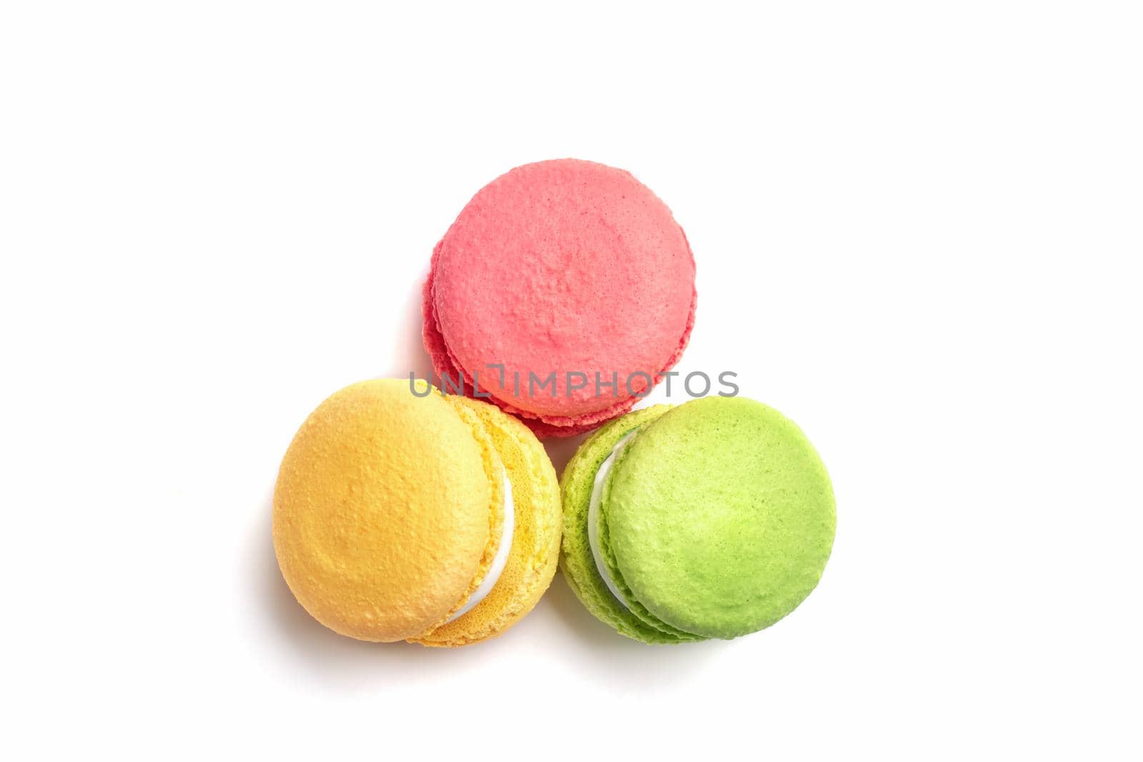 Banner of colorful macaroons isolated on white background. Lemon yellow, strawberry pink and green french cookies. Caramel hazelnut and strawberry cakes in front view. Bakery concept with blank space