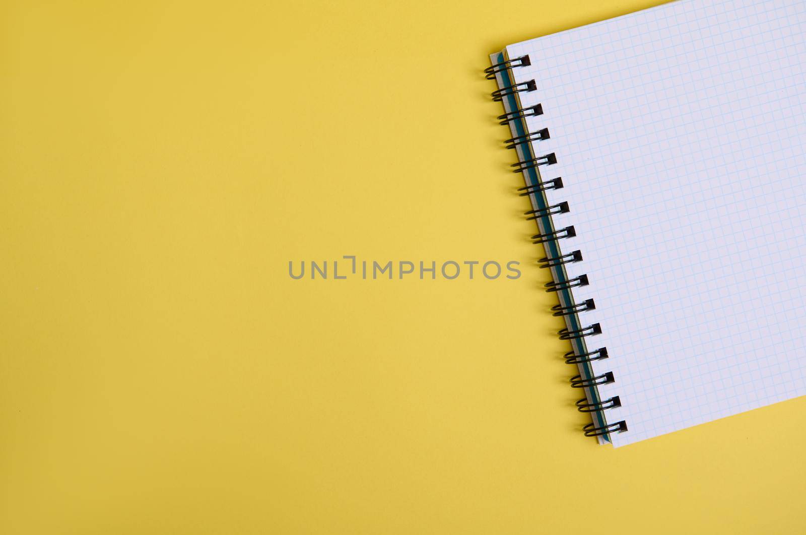Flat lay a cropped organizer notepad with blank white sheets , isolated on yellow background with copy space by artgf