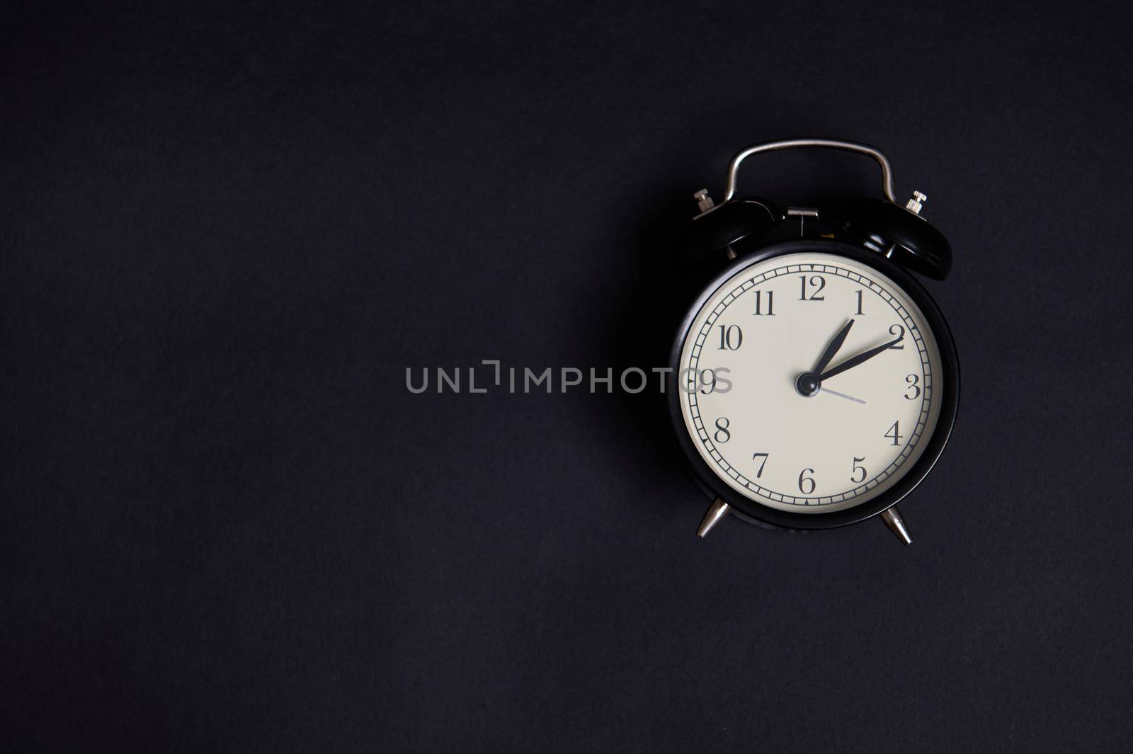 Flat lay. Monochrome composition with a vintage alarm clock on black background with copy space to add text. Back to School and Teachers Day Concepts, Business, Organization, Time Management by artgf