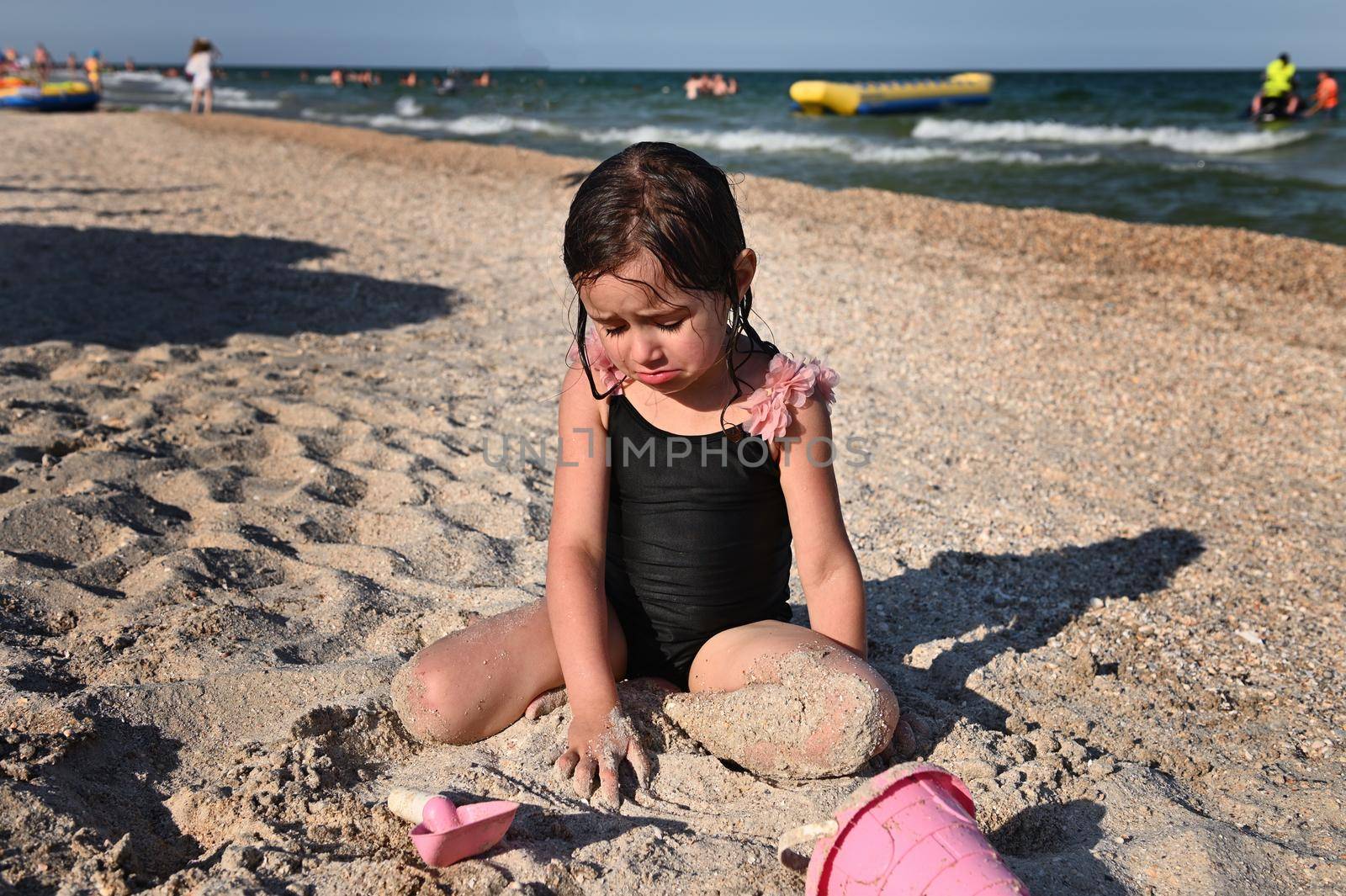 Summer holidays concept. Active lifestyles and happy summer vacations. Summer vacation. Adorable toddler girl playing with beach toys on the sandy beach.