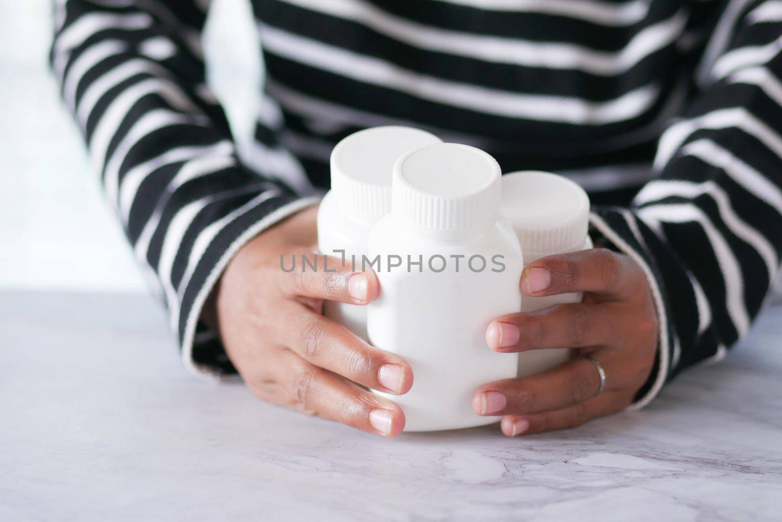 young man hand holding medicine pill container .