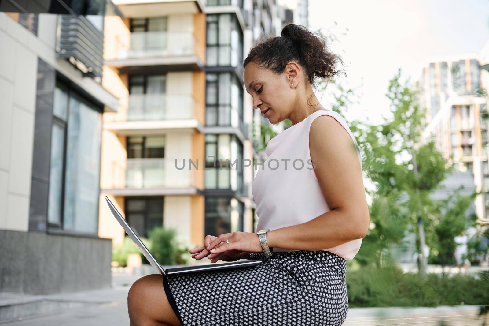 African American mature business woman working on laptop outdoor. Business, distant remote work and start-up concept