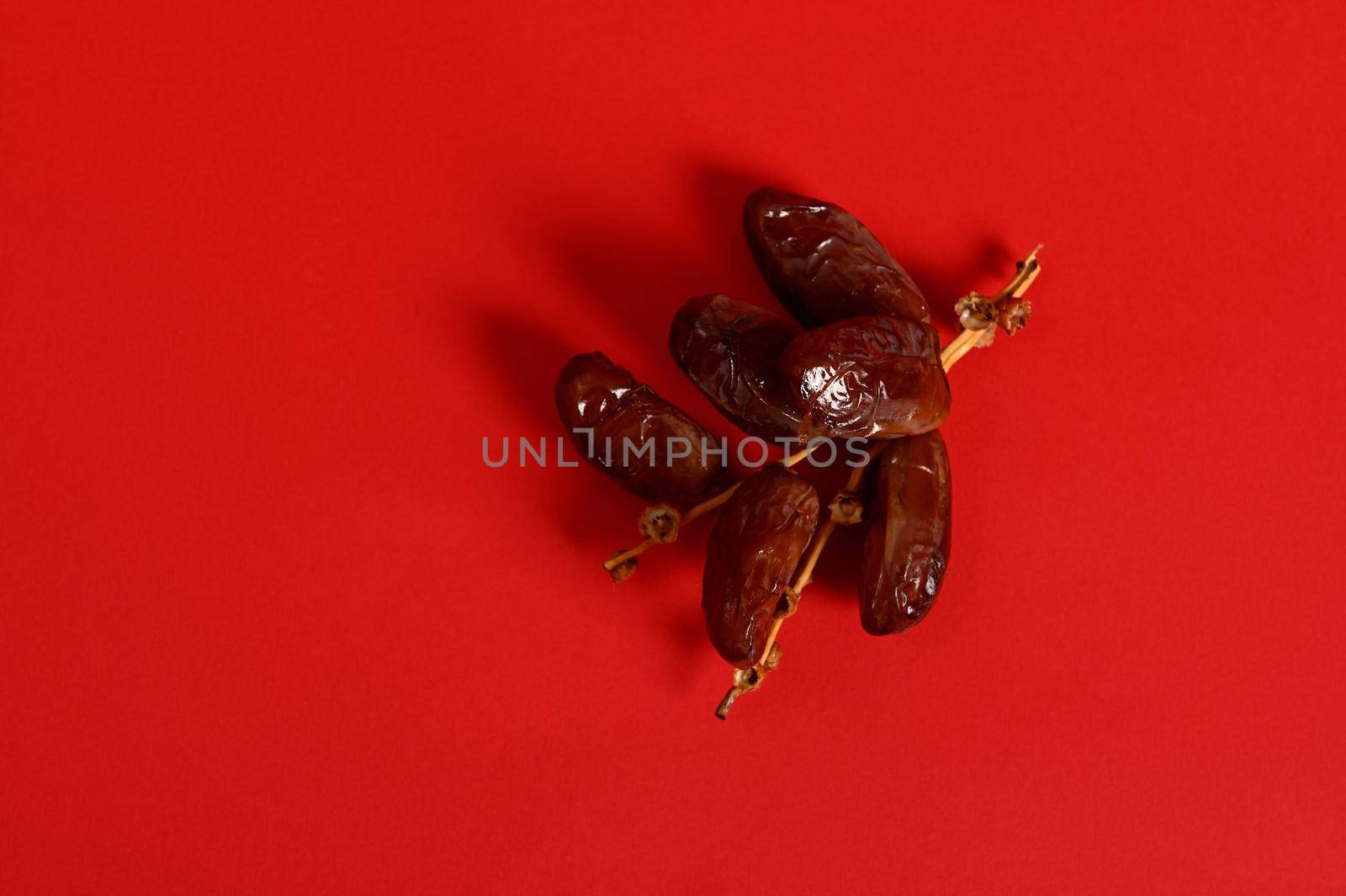 Flat lay with a branch of fresh tasty sweet dates for breakfast after interruption and fasting in Ramadan by artgf
