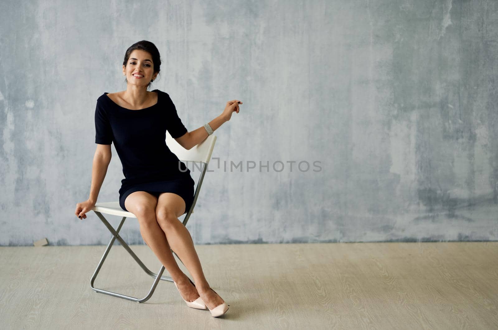 Woman in black dress sitting on chair posing luxury decoration fashion by SHOTPRIME