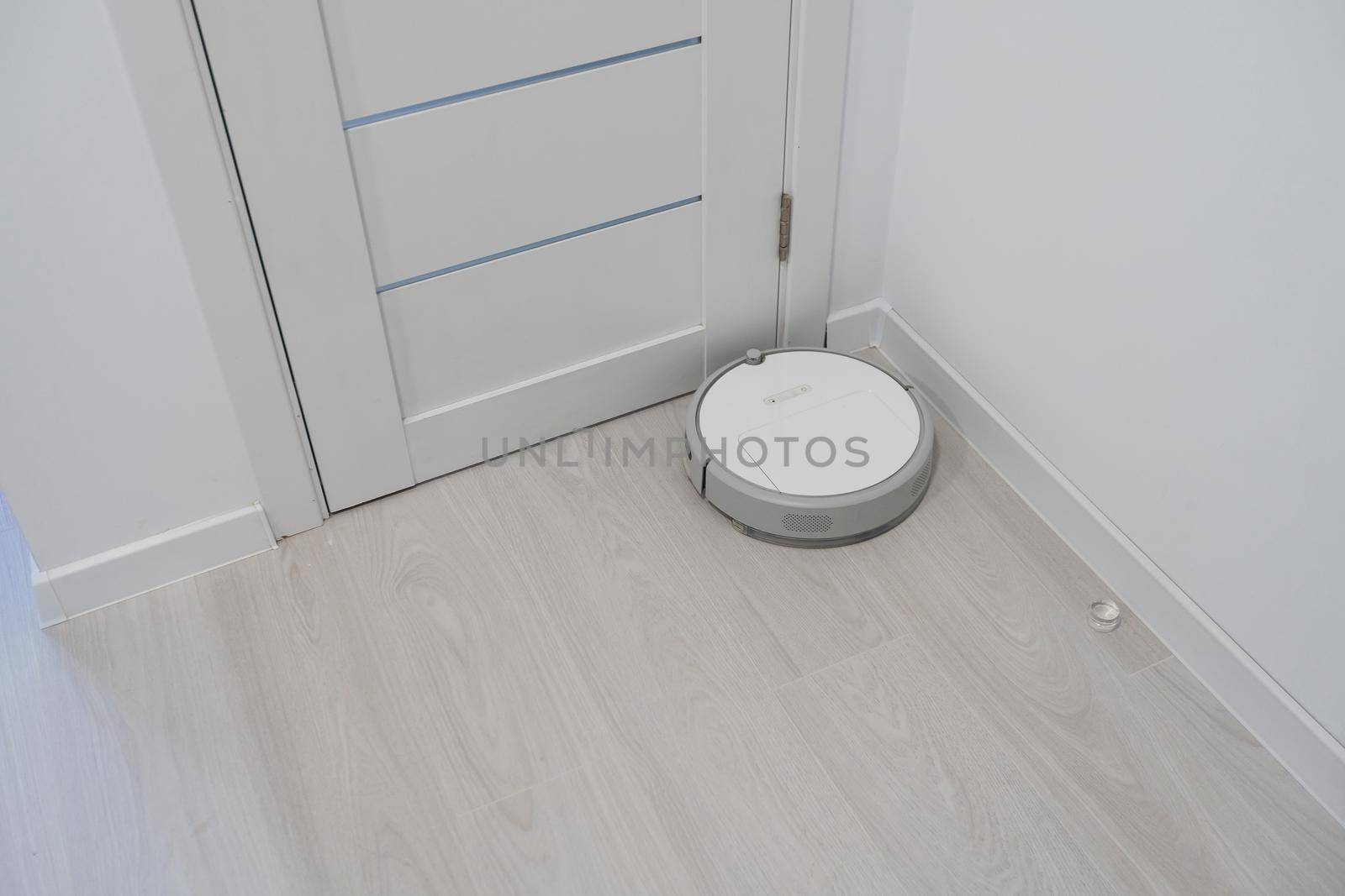 Robot vacuum cleaner performs automatic cleaning of the apartment at a certain time. Smart home by Andelov13