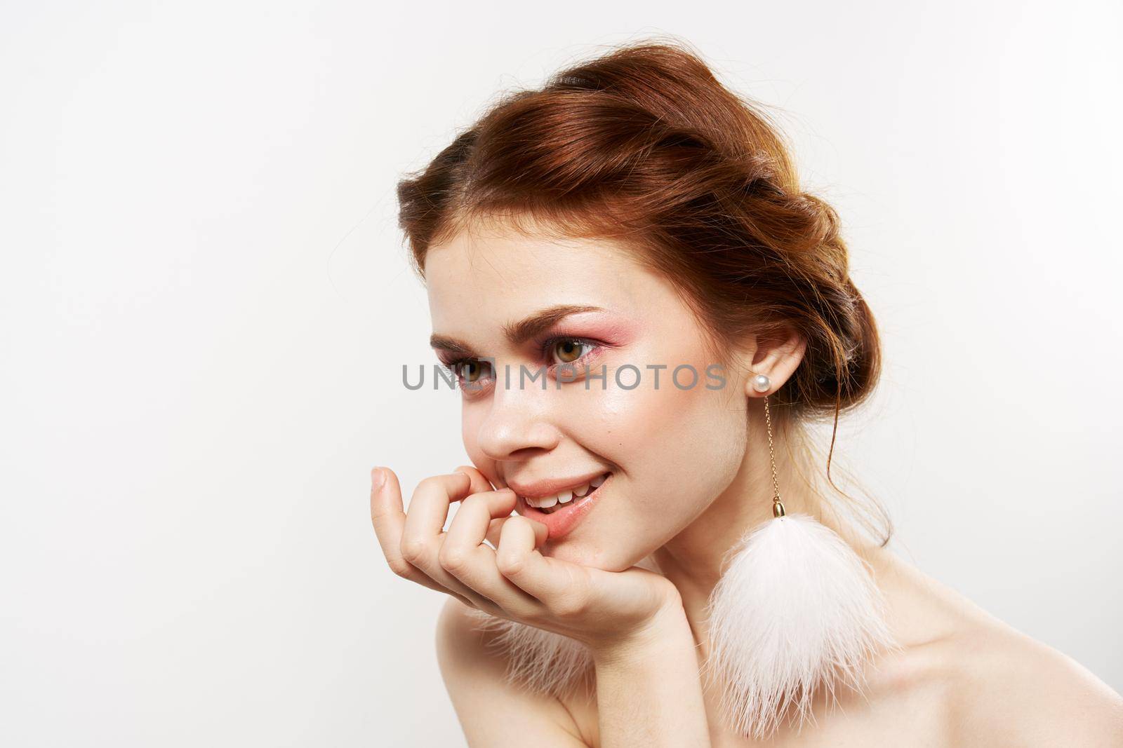 pretty woman fluffy earrings bare shoulders close-up bright makeup. High quality photo