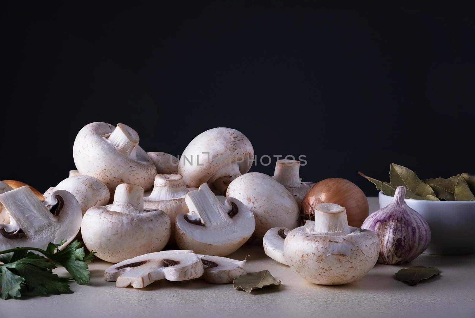 Bunch of raw champignons with other cooking ingredients. Mushrooms are like vegetable protein. Concept of vegetarian and vegan food. Veganism and vegetarianism. Cooking at home or in restaurant.