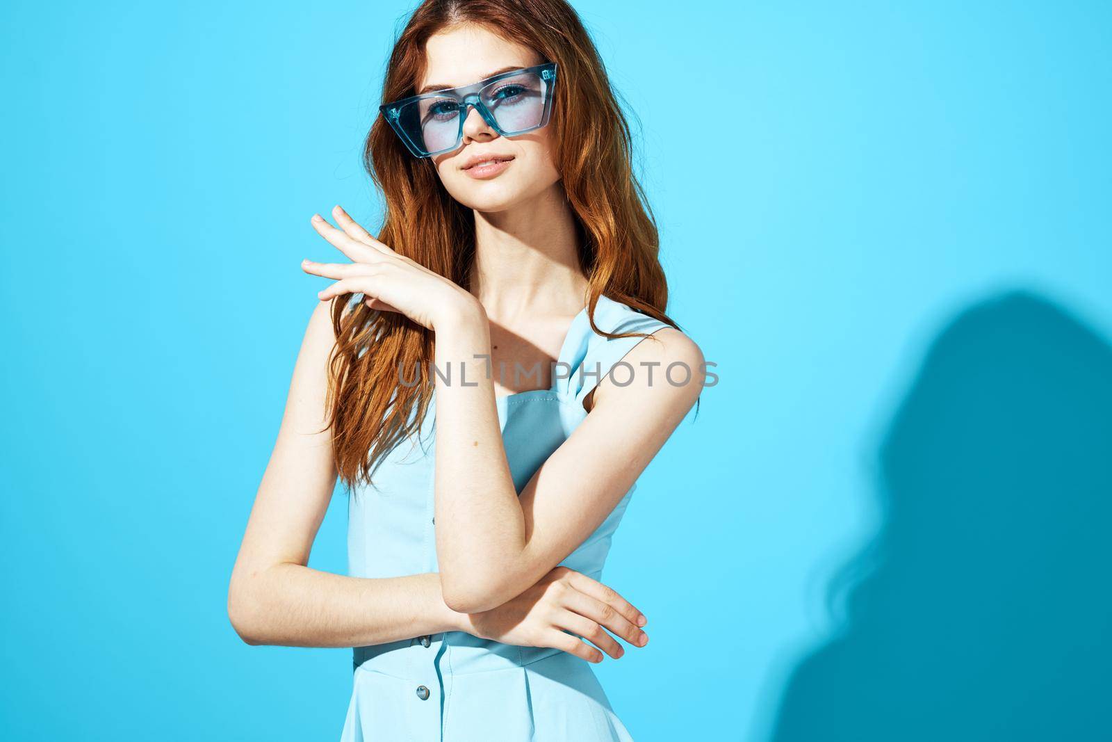 beautiful woman in fashionable glasses blue background Lifestyle. High quality photo